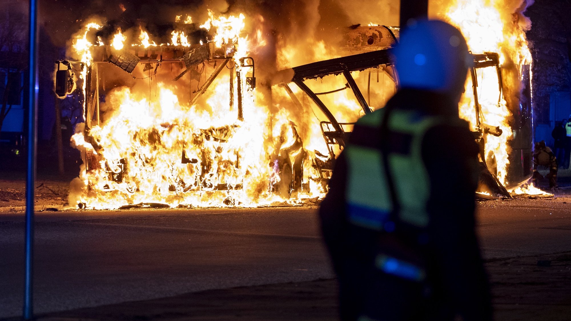 epa09894064 Riot police on site while a city bus burns on Vastra Kattarpsvagen on Rosengard in Malmo, Sweden, 17 April 2022. The unrest in Malmo has continued after Rasmus Paludan, party leader of the Danish right-wing extremist party Tight Course, held a demonstration at Skanegarden near the Oresund Bridge. Paludan had received permission for a gathering in Landskrona, but the police moved the demonstration to Malmo.  EPA/Johan Nilsson  SWEDEN OUT