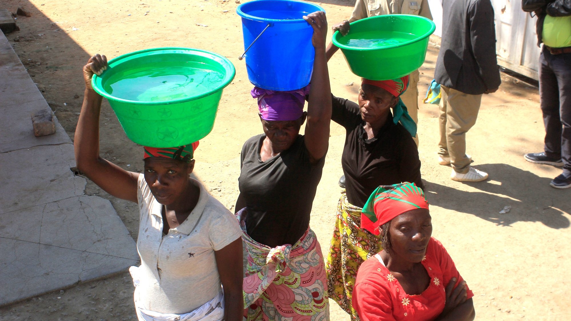 Mulheres transportam na cabeça alguidares com água, no Huambo, Angola, 30 de maio de 2019. AMPE ROGÉRIO/LUSA