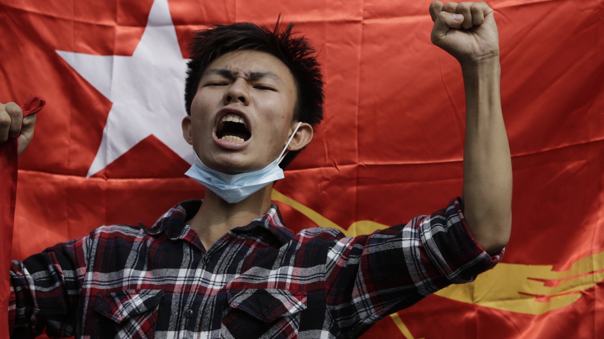 epa09711507 (31/31) (FILE) - A protester shouts slogans in front of a National League for Democracy (NLD) flag during a protest against the military, in Yangon, Myanmar, 06 February 2021 (reissued 27 January 2022). On 01 February 2021 the Myanmar Army arrested democratically elected political leaders and seized control of the country. Protests erupted nationwide leading to violent clashes and a military retaliation that had left at least 1,000 dead within the first six months. According to the United Nations, by early December 2021 over 280,000 people were still internally displaced in Myanmar due to armed clashes and insecurity.  EPA/STRINGER  ATTENTION: This Image is part of a PHOTO SET