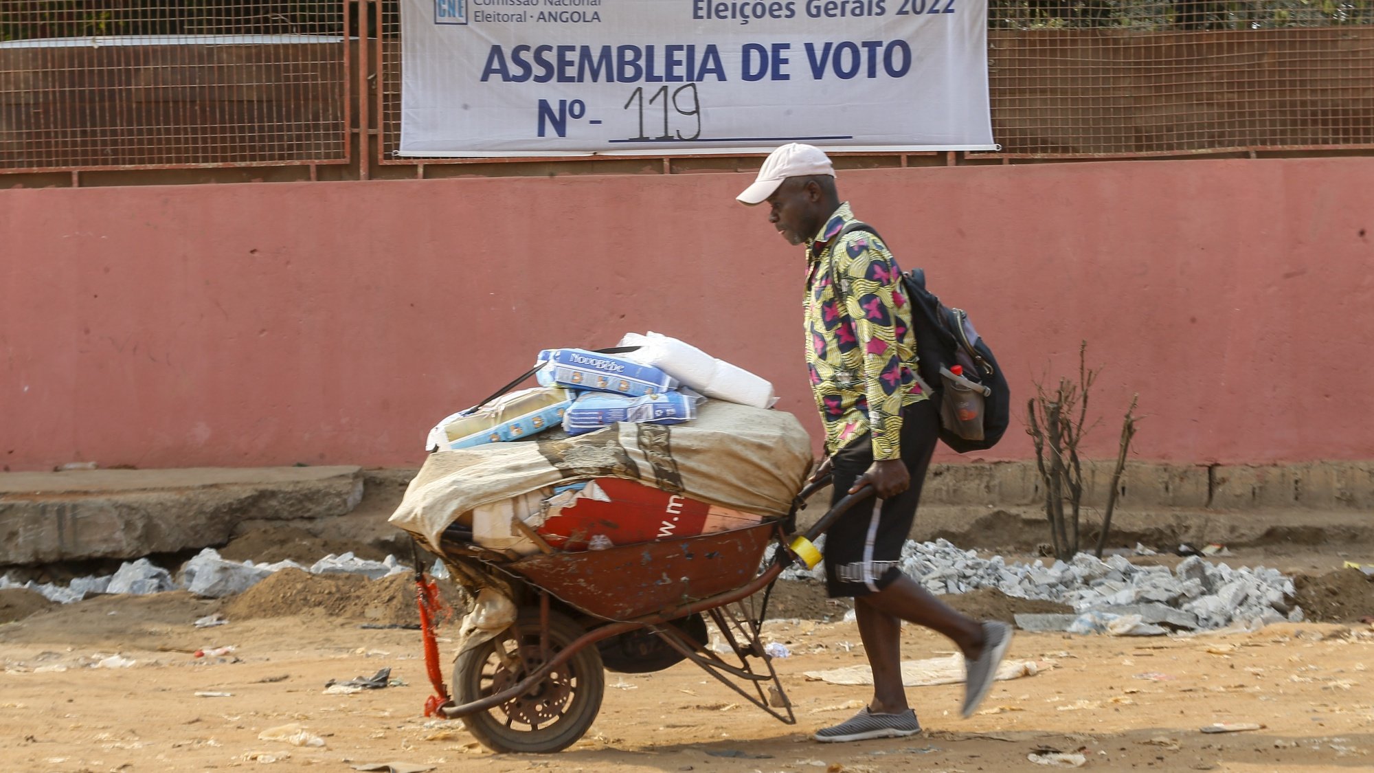 Um popular passa junto de um cartaz da Comissão Nacional de Eleições de Angola, Luanda, Angola, 10 de agosto de 2022. As eleições gerais angolanas, quinto escrutínio da história política do país, estão marcadas para 24 de agosto e contam com candidaturas de oito formações políticas, que estão em campanha eleitoral desde 24 de julho. (ACOMPANHA TEXTO DE 13-08-2022)  AMPE ROGÉRIO/LUSA