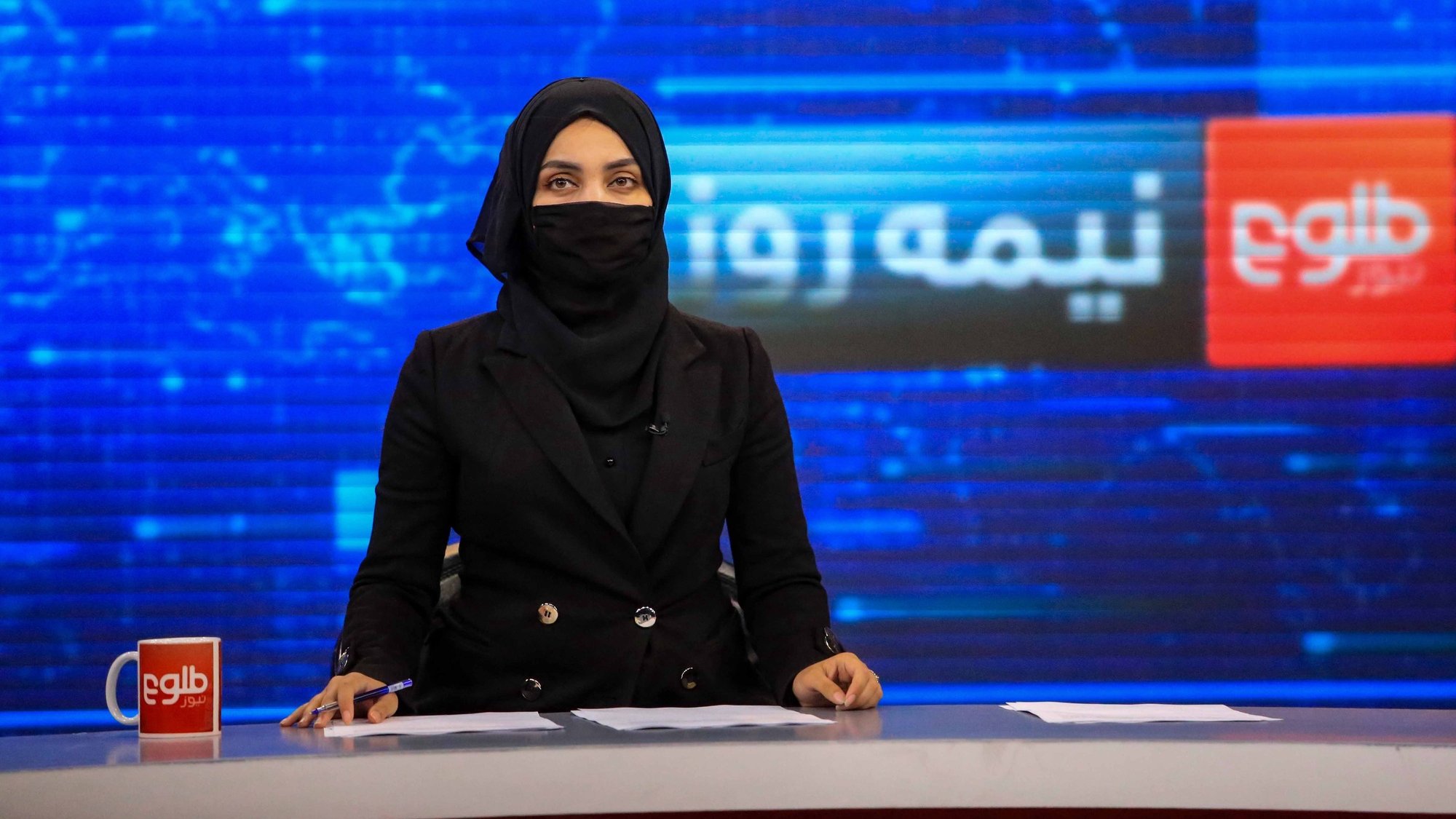 epa09969634 Khatira Ahmadi, an Afghan presenter at Tolo TV reads news at the studio in Kabul, Afghanistan, 23 May 2022. Female television presenters and reporters in Afghanistan appeared with their faces covered on 22 May to comply with a mandate issued by the Taliban. The Taliban had asked the media to obey the 07 May decree which imposed the mandatory use of the burqa or similar face covering for women.  EPA/STRINGER