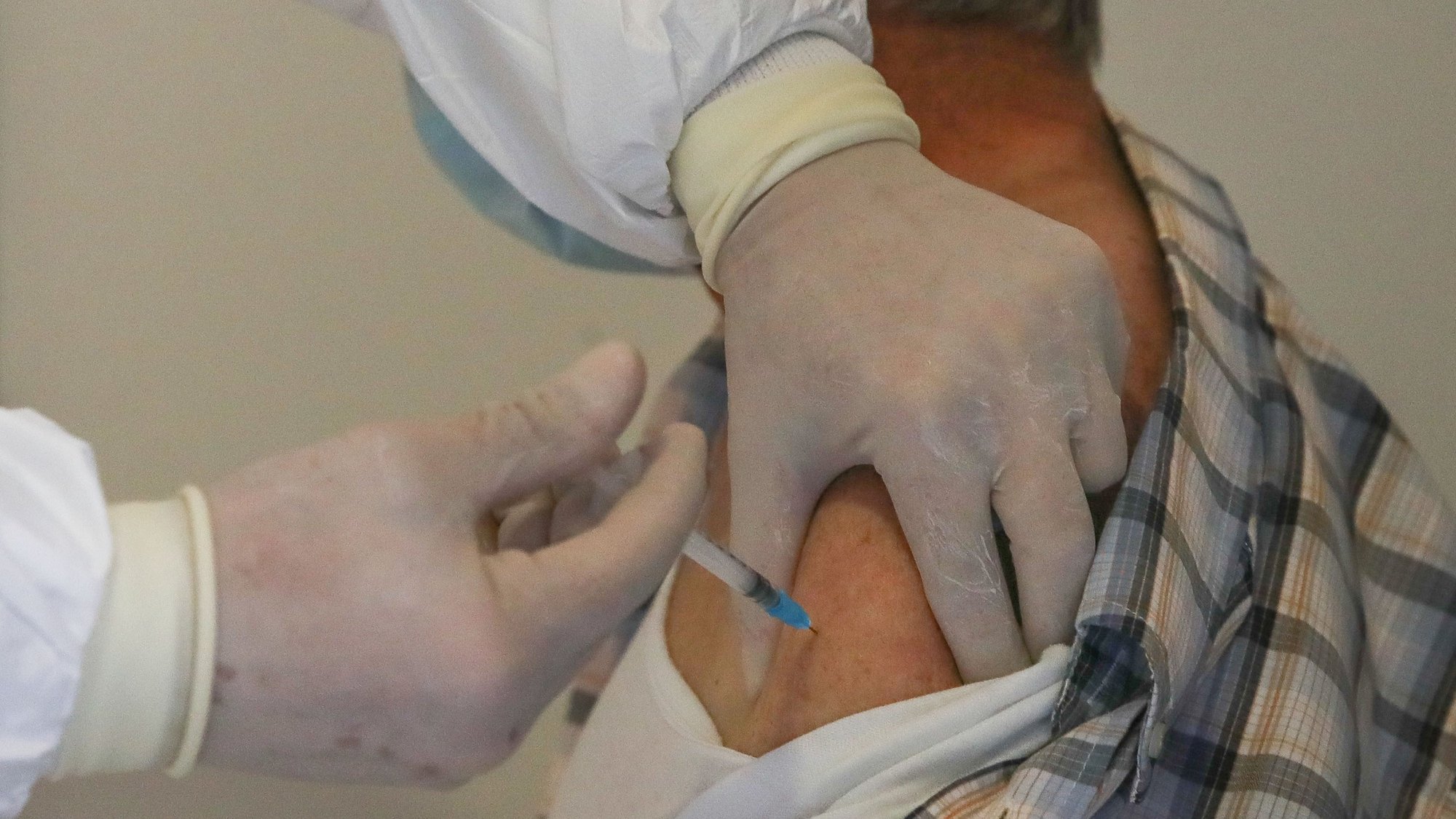 Um idoso é vacinado contra a covid-19 por um profissional de saúde no Centro de Vacinação de Arganil, durante o processo de vacinação na Antiga Cerâmica Arganilense, em Arganil, 19 de março de 2021. (ACOMPANHA TEXTO). PAULO NOVAIS/LUSA