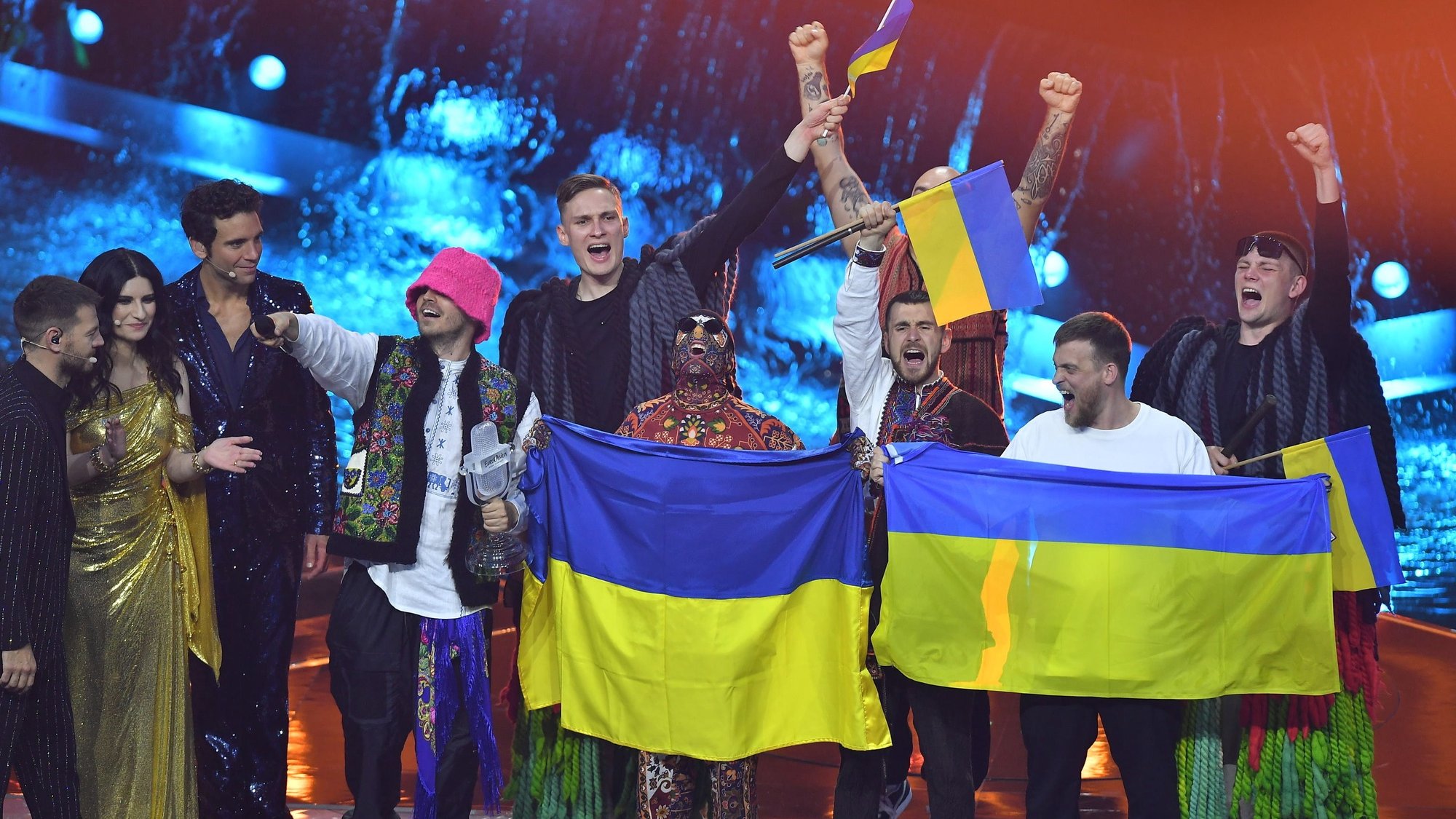epaselect epa09947796 Kalush Orchestra from Ukraine celebrates onstage, together with presenters Alessandro Cattelan, Laura Pausini, and Mika, after  winning the 66th annual Eurovision Song Contest (ESC 2022) in Turin, Italy, 14 May 2022.  EPA/ALESSANDRO DI MARCO