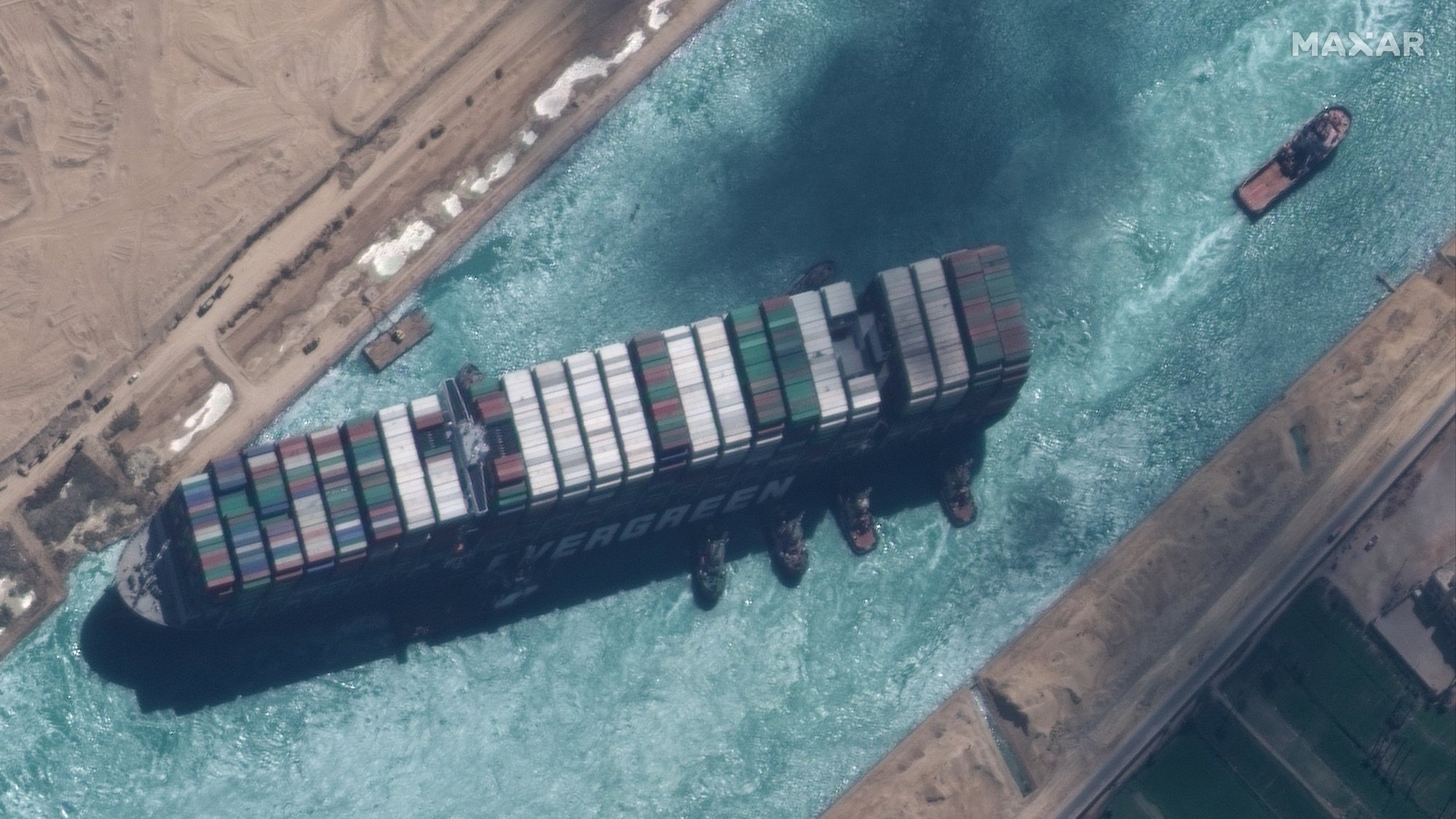 epa09105214 A handout satellite image made available by MAXAR Technologies shows , the Ever Given container ship after it has been moved away from the eastern bank of the canal and tugboats trying to reposition the ship, in the Suez Canal, Egypt, 29 March 2021. The head of the Suez Canal Authority announced on 29 March that the large container ship, which ran aground in the Suez Canal on 23 March, is now free floating after responding to the pulling maneuvers.  EPA/MAXAR TECHNOLOGIES HANDOUT MANDATORY CREDIT: SATELLITE IMAGE 2020 MAXAR TECHNOLOGIES -- the watermark may not be removed/cropped -- HANDOUT EDITORIAL USE ONLY/NO SALES HANDOUT EDITORIAL USE ONLY/NO SALES