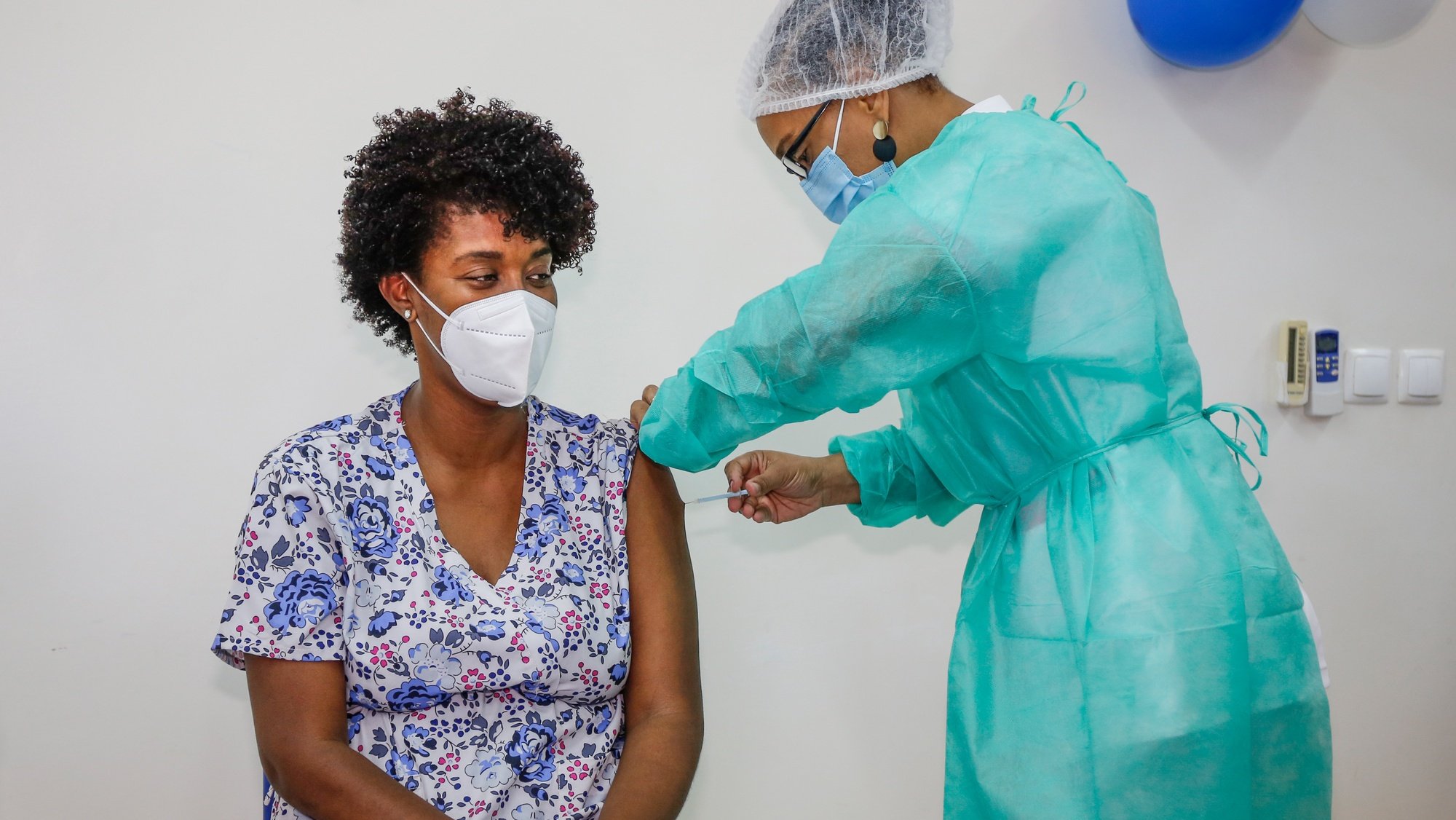 Uma profissional de saúde administra a vacina da Pfizer a covid-19 a um dos seis profissionais de saúde da Praia, antecedendo o início da campanha de vacinação em Cabo Verde, sexta-feira, precisamente um ano depois da chegada da pandemia ao arquipélago, no Centro de Saúde da Achada de Santo António, na Praia, Cabo Verde, 18 de março de 2021. FERNANDO DE PINA/LUSA