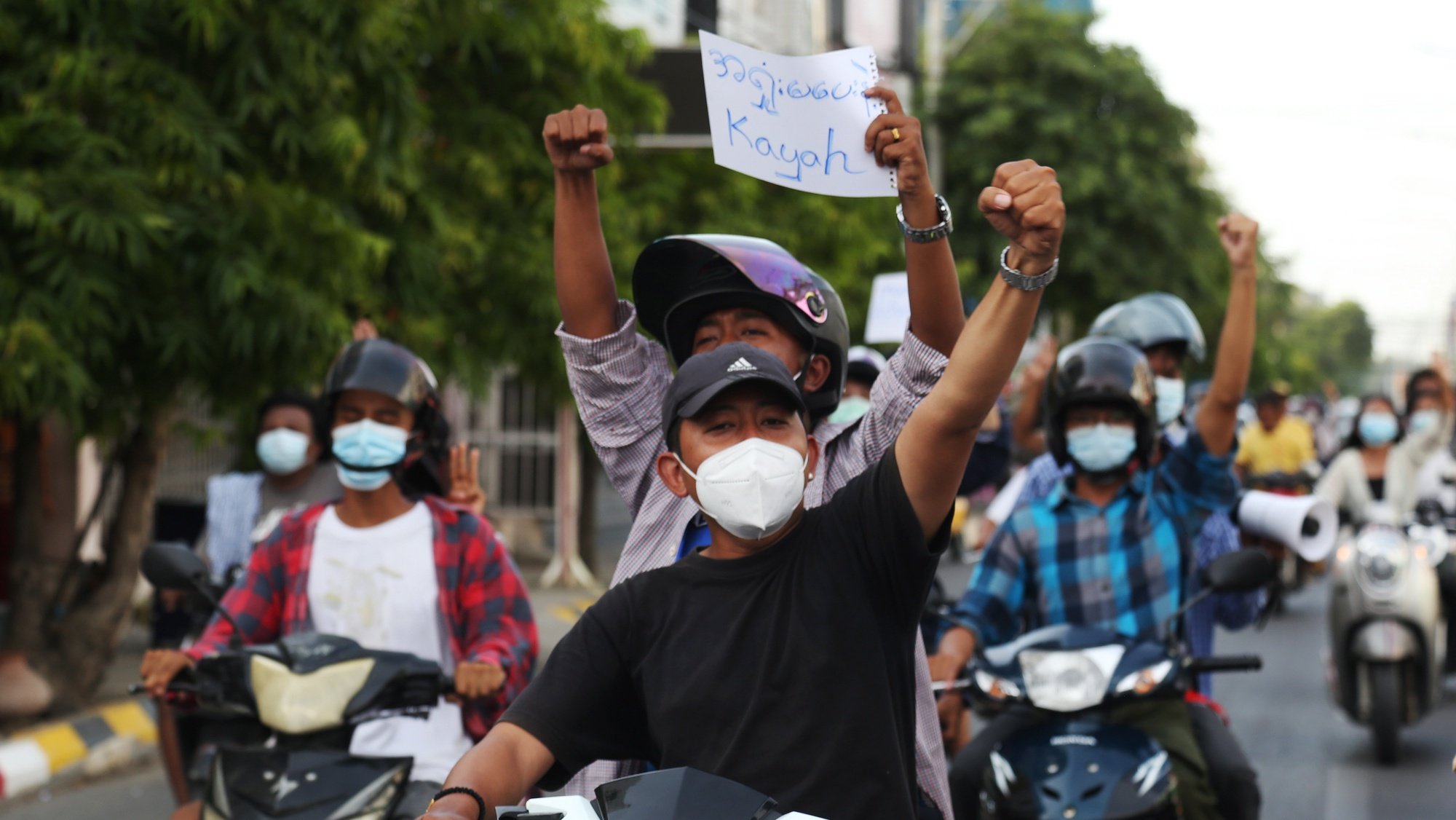 epa09217702 Demonstrators gesture and hold a placard reading &#039;Don&#039;t surrender, Kayah&#039; while riding on motorcycles during a protest against the military coup in Mandalay, Myanmar, 21 May 2021. At least 800 people have been killed by Myanmar armed forces and more than 4,000 detained since the military seized power on 01 February 2021, according to the Assistance Association for Political Prisoners (AAPP).  EPA/STRINGER