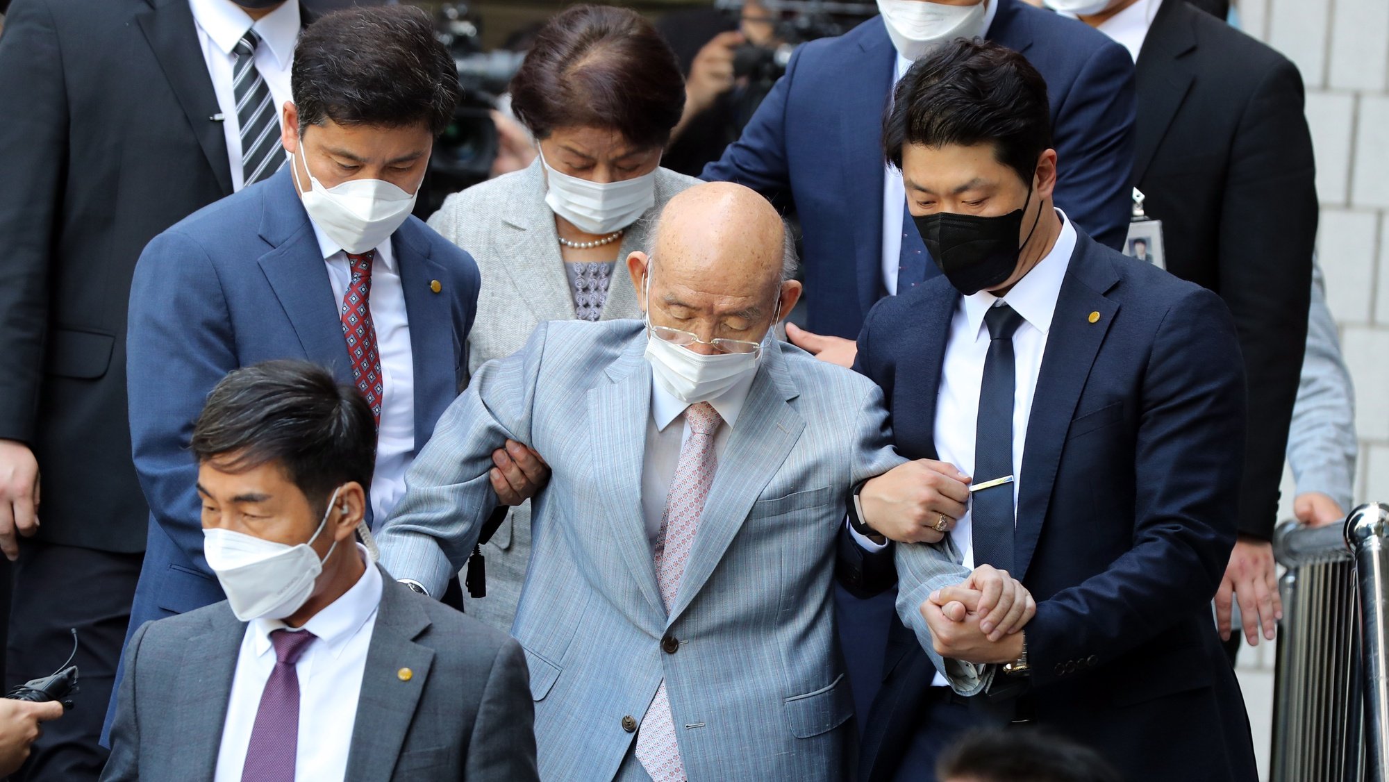 epa09598399 Former President Chun Doo-hwan (C), escorted by security guards, leaves a district court in the southwestern city of Gwangju, South Korea, 09 August 2021 (issued 23 November 2021), after attending an appellate trial on the charge of libel. Chun, a general-turned strongman who seized power through a 1979 military coup and ruthlessly quelled a pro-democracy civil uprising in the city the following year, died on 23 November 2021, aides said. He was 90.  EPA/YONHAP SOUTH KOREA OUT