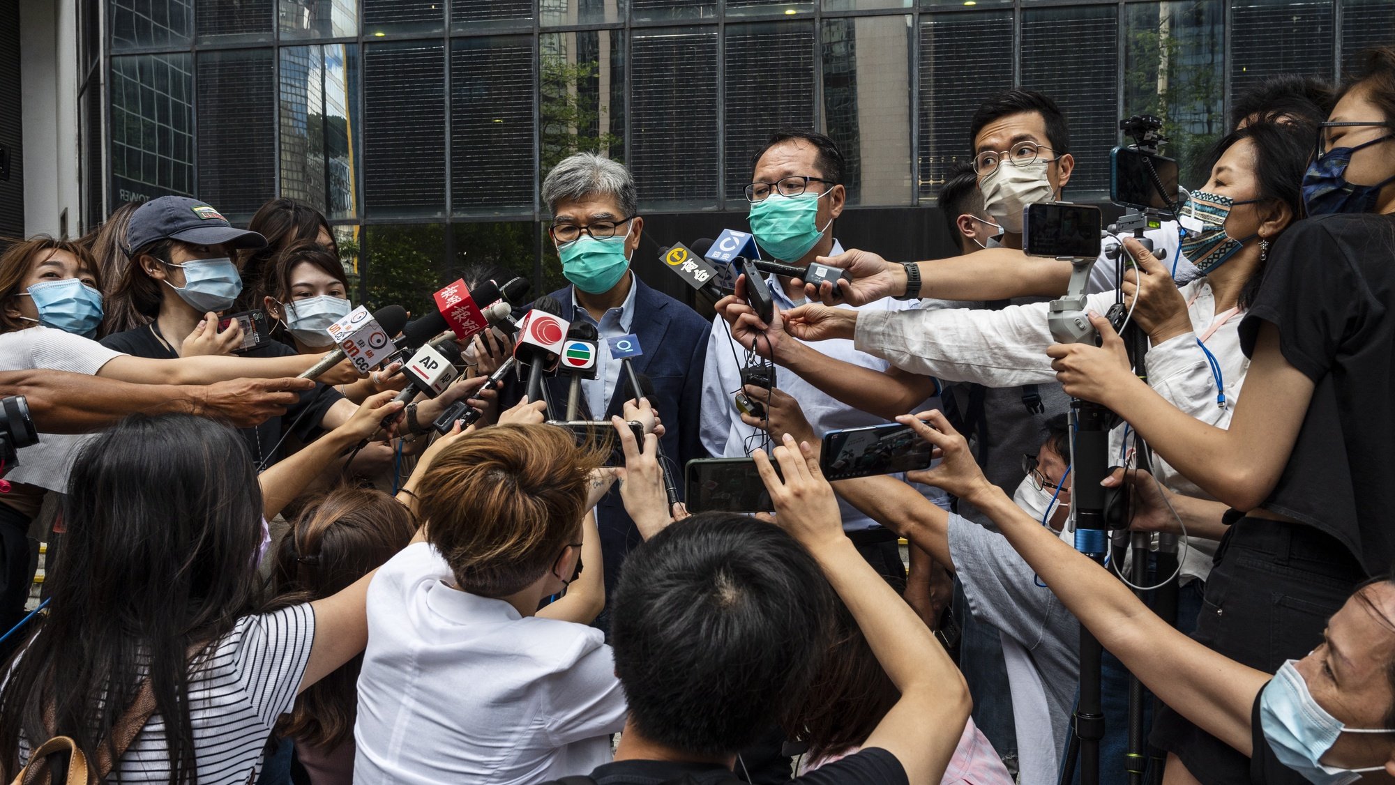epa09232873 Pro-democracy activists Sin Chung-kai (L) and Richard Tsoi (R) speak to the media outside the West Kowloon Law Courts building as their jail terms were suspended in Hong Kong, China, 28 May 2021. Lai, Leung Kwok-hung, better known &#039;Long Hair&#039;, and other prominent activists are handed a prison terms ranging from 14 months to 18 months, for organising unauthorized National Day assembly.  EPA/MIGUEL CANDELA