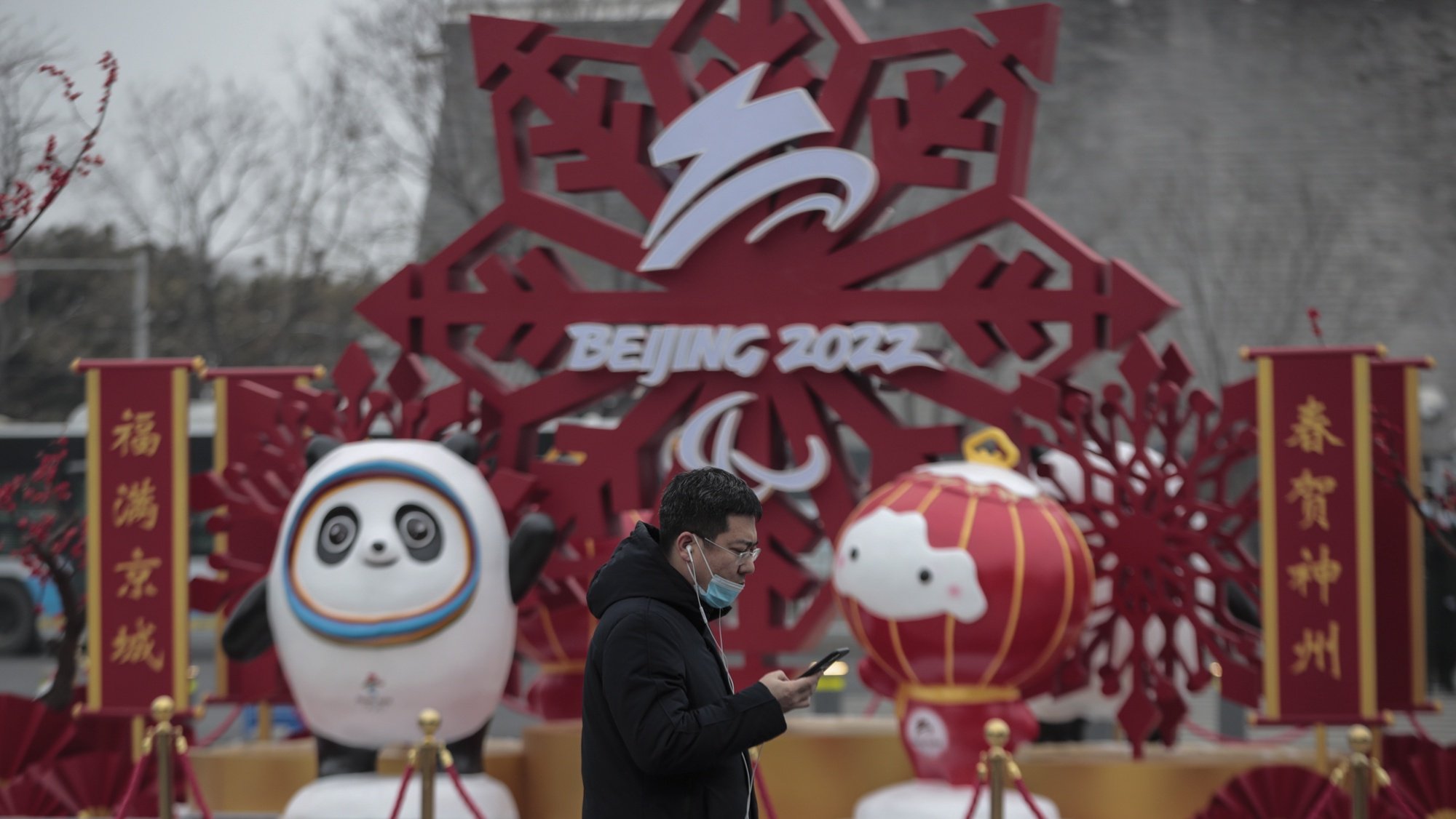 epa09705931 A man wearing face mask walks pass the Bing Dwen Dwen, the Beijing 2022 Winter Olympic Mascot and Shuey Rhon Rhon, the 2022 Beijing Winter Paralympic Games Mascot, in Beijing, China, 24 January 2022. China is scheduled to host the Beijing 2022 Olympic and Paralympic Winter Games in February, making its capital the first city in the world to host both Summer (2008) and Winter Olympics (2022).  EPA/WU HONG