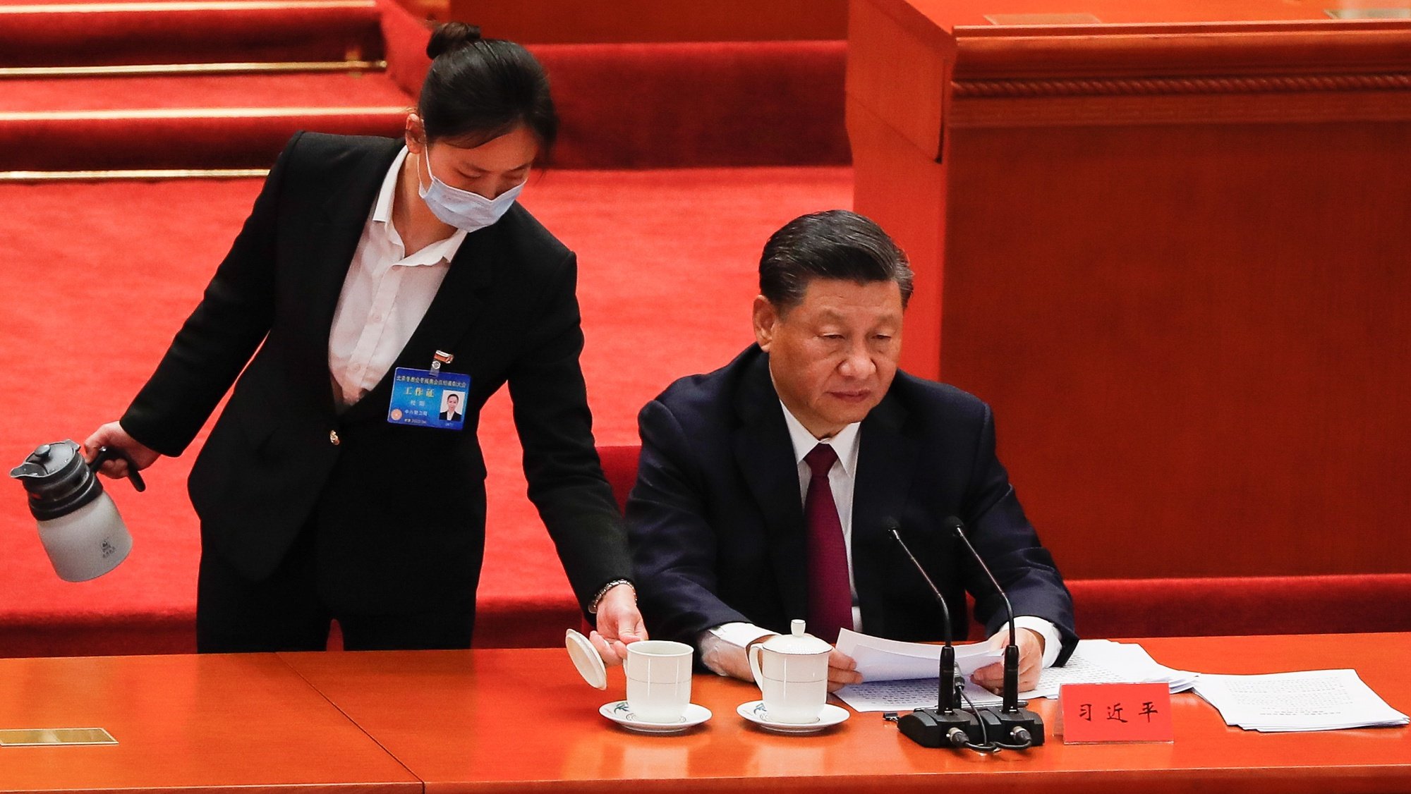 epa09877775 A staff serves tea to Chinese President Xi Jinping (R) during his speech at a meeting commending role models of the Beijing 2022 Olympic Winter Games and Paralympic Winter Games at the Great Hall of the People in Beijing, China, 08 April 2022. The 2022 Winter Olympics was held in Beijing from 04 to 20 February, while the 2022 Winter Paralympics from 04 to 13 March 2022.  EPA/MARK R. CRISTINO