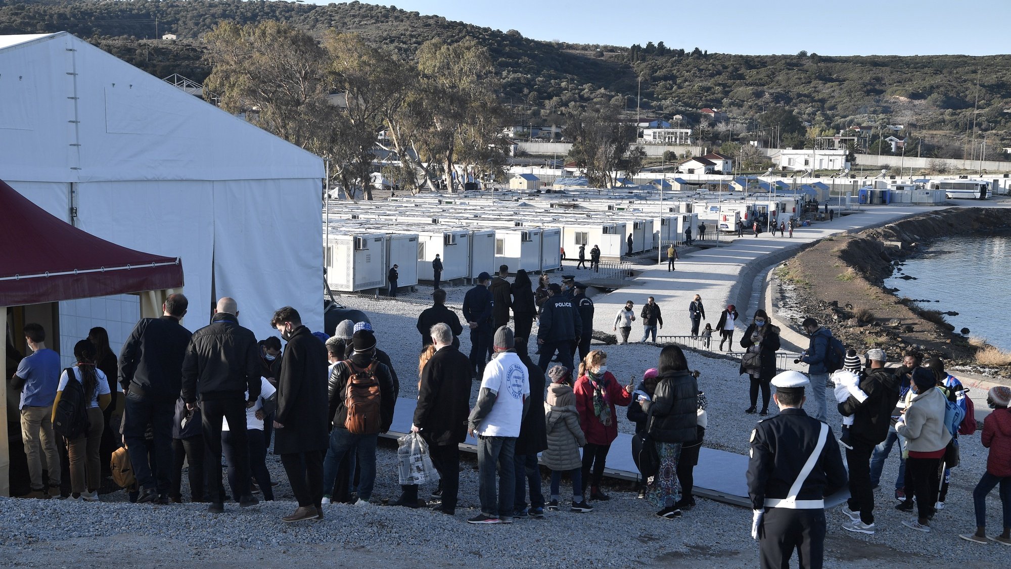 epa09623010 Refugees queue outside the Moria detention centre for migrants and refugees near Mytilene prior the meeting with Pope Francis on the island of Lesbos, Greece 05 December  2021. Pope Francis returns to the island of Lesbos, the migration flashpoint he first visited in 2016, to plead for better treatment of refugees as attitudes towards immigrants harden across Europe.  EPA/LOUISA GOULIAMAKI / POOL