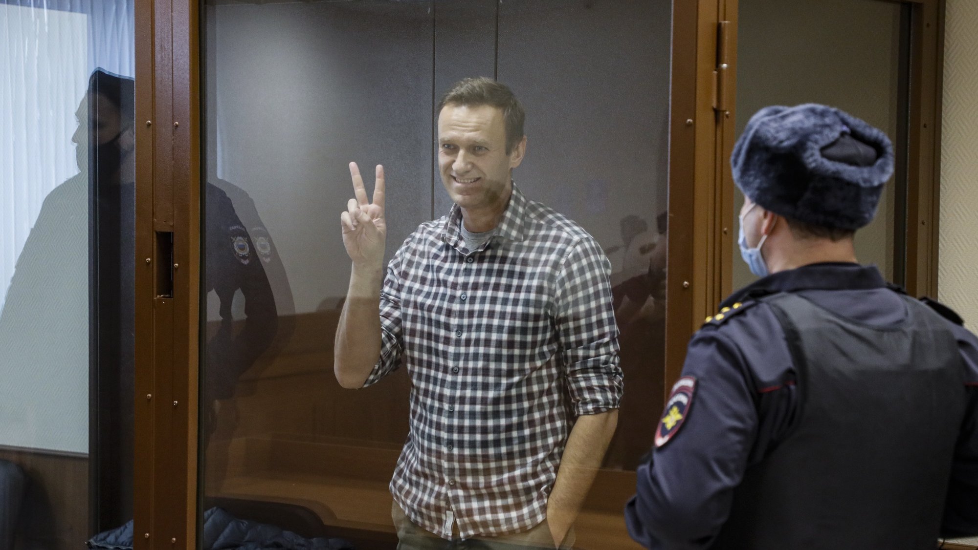 epaselect epa09025242 Russian opposition leader Alexei Navalny gestures inside a glass cage prior to a hearing at the Babushkinsky District Court in Moscow, Russia, 20 February 2021. The Moscow City court will hold a visiting session at the Babushkinsky District Court Building to consider Navalny&#039;s lawyers appeal against a court verdict issued on 02 February 2021, to replace the suspended sentence issued to Navalny in the Yves Rocher embezzlement case with an actual term in a penal colony.  EPA/YURI KOCHETKOV MANDATORY CREDIT