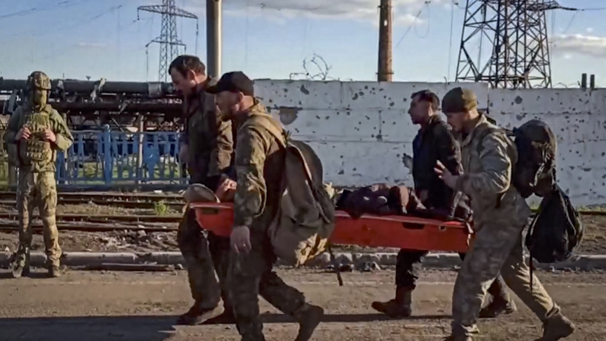 epa09952378 A handout still image taken from a handout video made available by the Russian Defence Ministry&#039;s press service shows Ukrainian servicemen carry a wounded comrade as they are being evacuated from the besieged Azovstal steel plant in Mariupol, Ukraine, 17 May 2022. A total of 265 Ukrainian militants, including 51 seriously wounded, have laid down arms and surrendered to Russian forces, the Russian Ministry of Defence said on 17 May 2022. Those in need of medical assistance were sent for treatment to a hospital in Novoazovsk, the ministry states further. Russian President Putin on 21 April 2022 ordered his Defence Minister to not storm but to blockade the plant where a number of Ukrainian fighters were holding out. On 24 February, Russian troops invaded Ukrainian territory starting a conflict that has provoked destruction and a humanitarian crisis. According to the UNHCR, more than six million refugees have fled Ukraine, and a further 7.7 million people have been displaced internally within Ukraine since.  EPA/RUSSIAN DEFENCE MINISTRY PRESS SERVICE HANDOUT  BEST QUALITY AVAILABLE HANDOUT EDITORIAL USE ONLY/NO SALES