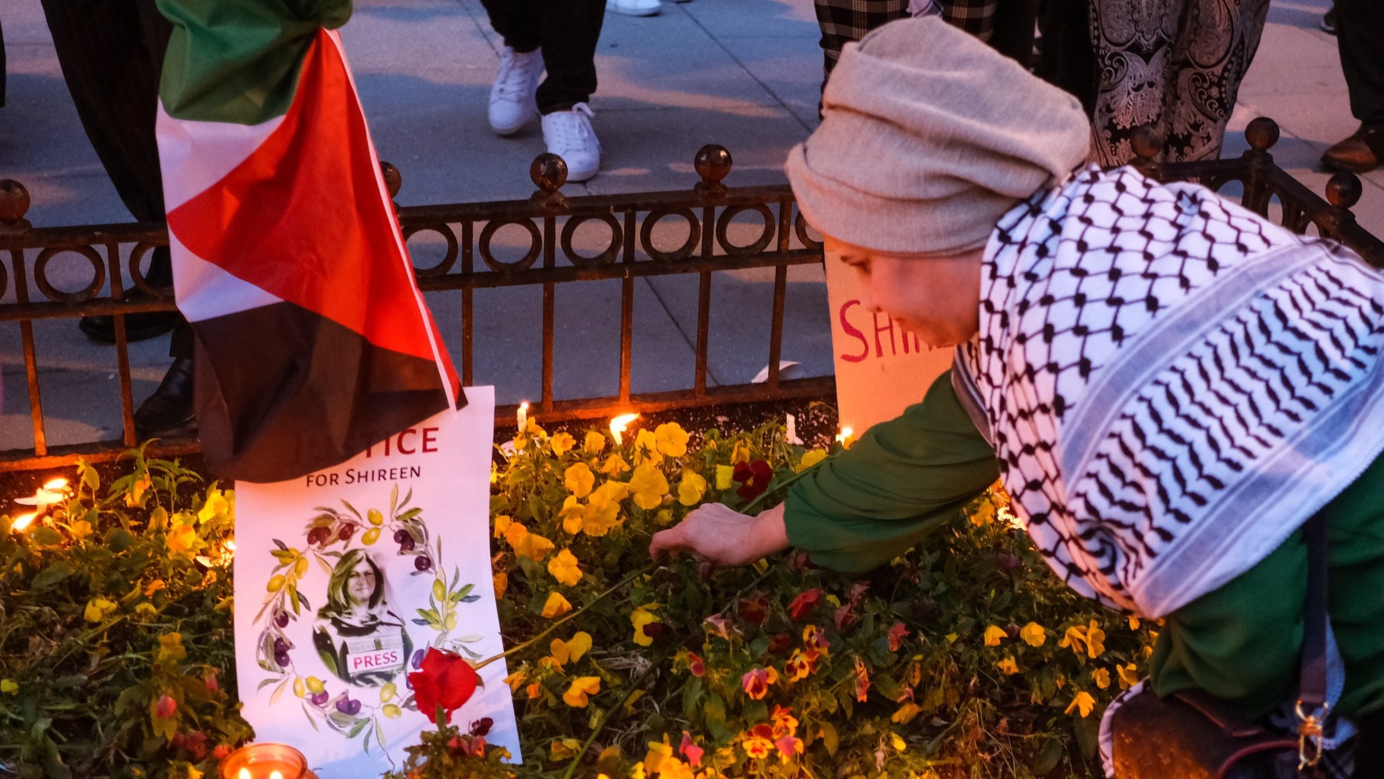 epa09954221 A woman places a flower on a make-shift memorial during a candlelight vigil to honor the slain al-Jazeera Journalist Shireen Abu Akleh, in Washington, DC, USA, 17 May 2022. Al Jazeera journalist Shireen Abu Akleh was killed on 11 May 2022 during a raid by Israeli forces in the West Bank town of Jenin.  EPA/GAMAL DIAB