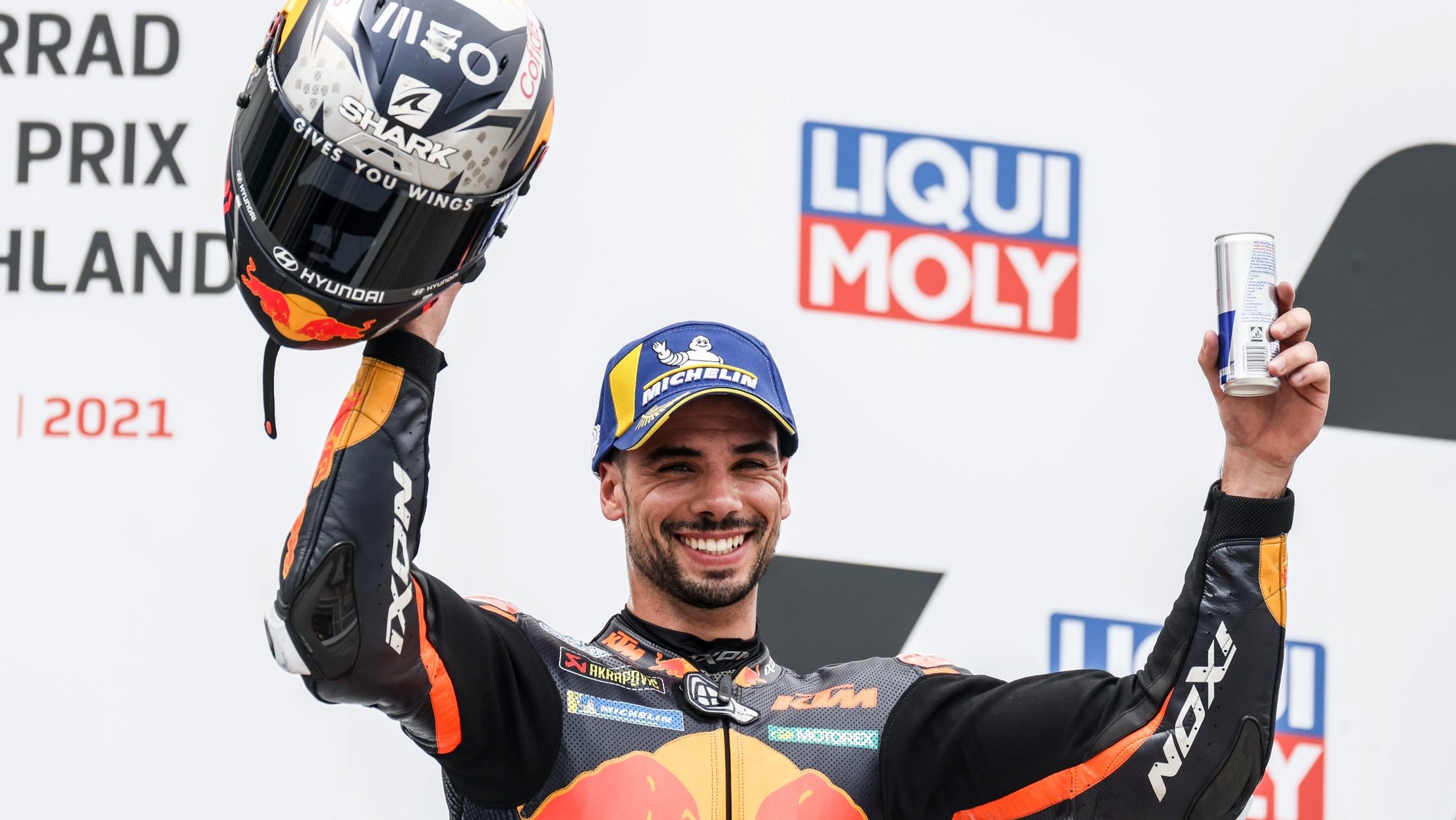 epa09288237 Portuguese MotoGP rider Miguel Oliveira of the Red Bull KTM Factory Racing team celebrates on the podium after taking the second place in the Motorcycling Grand Prix of Germany at the Sachsenring racing circuit in Hohenstein-Ernstthal, Germany, 20 June 2021.  EPA/FILIP SINGER