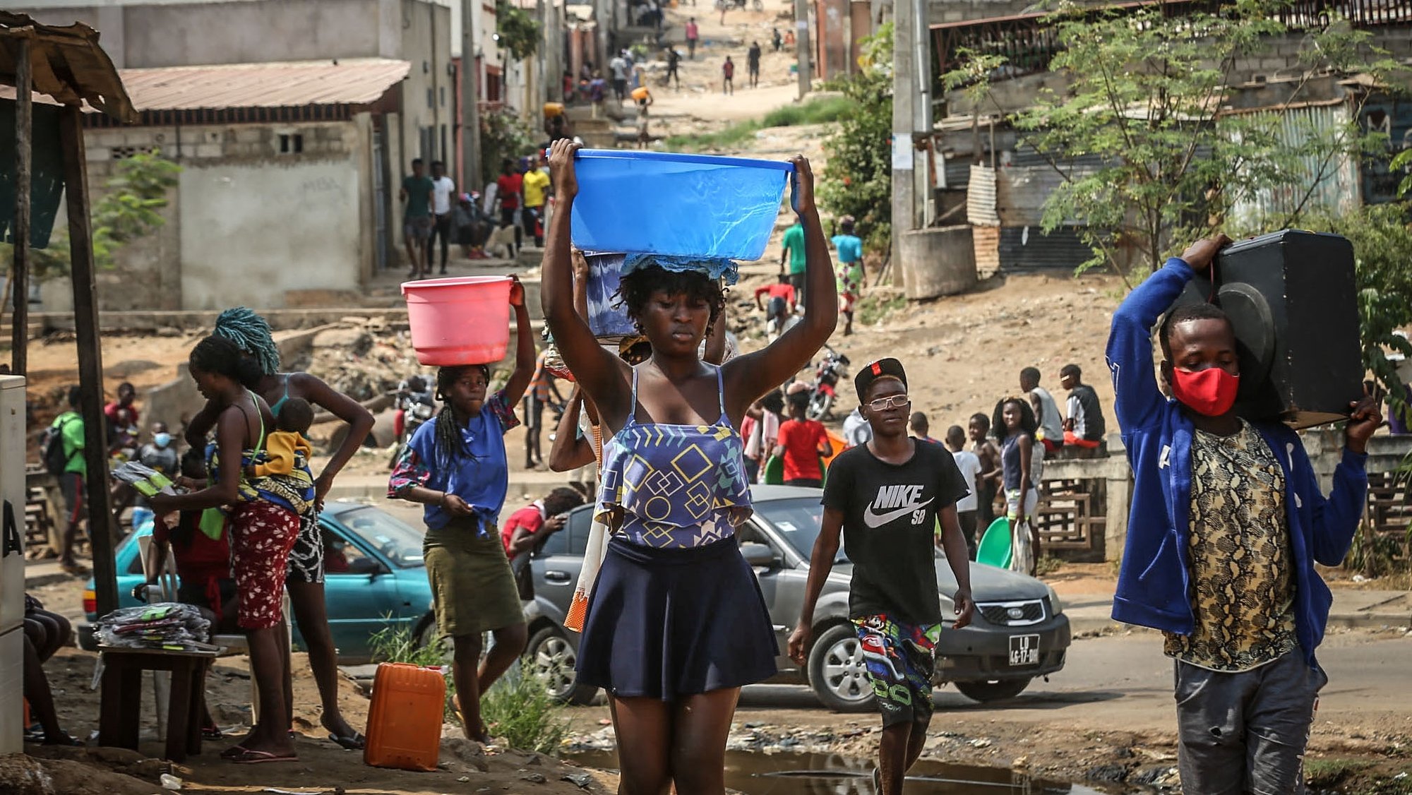 Crianças, jovens e adultos, em Luanda, &quot;lutam&quot;, numa tubagem pública, por eles &quot;danificada&quot;, à berma da estrada, para conseguir uma banheira ou balde de água que, há semanas, não jorra naquela circunscrição do município do Cazenga, 21 junho 2021. (ACOMPANHA TEXTO DO DIA 25 JUNHO 2021).  AMPE ROGERIO / LUSA