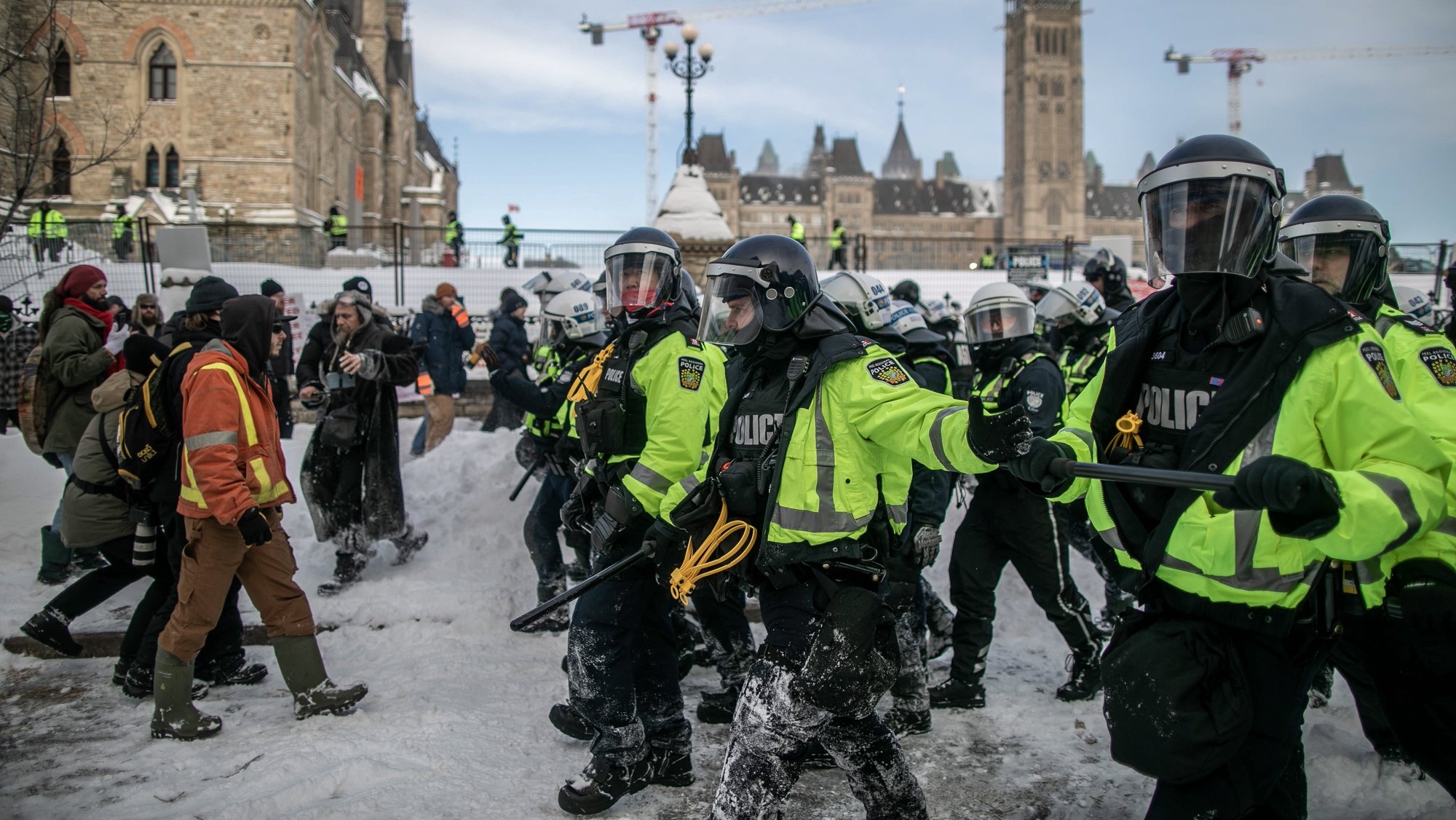 epa09773057 Police forces clash with protesters in Ottawa  city center as they clear a protest by Canadian truck drivers over Covid-19 restrictions which has led to gridlock in Ottawa, Canada, 19 February 2022. The protest is against the mandate by the Canadian government that truckers must be vaccinated. Police moved in on 18 and 19 February to clear protesters and dozens of arrests were made. Willington street where the parliament hill is located was cleared of all protesters on 19 February.  EPA/AMRU SALAHUDDIEN