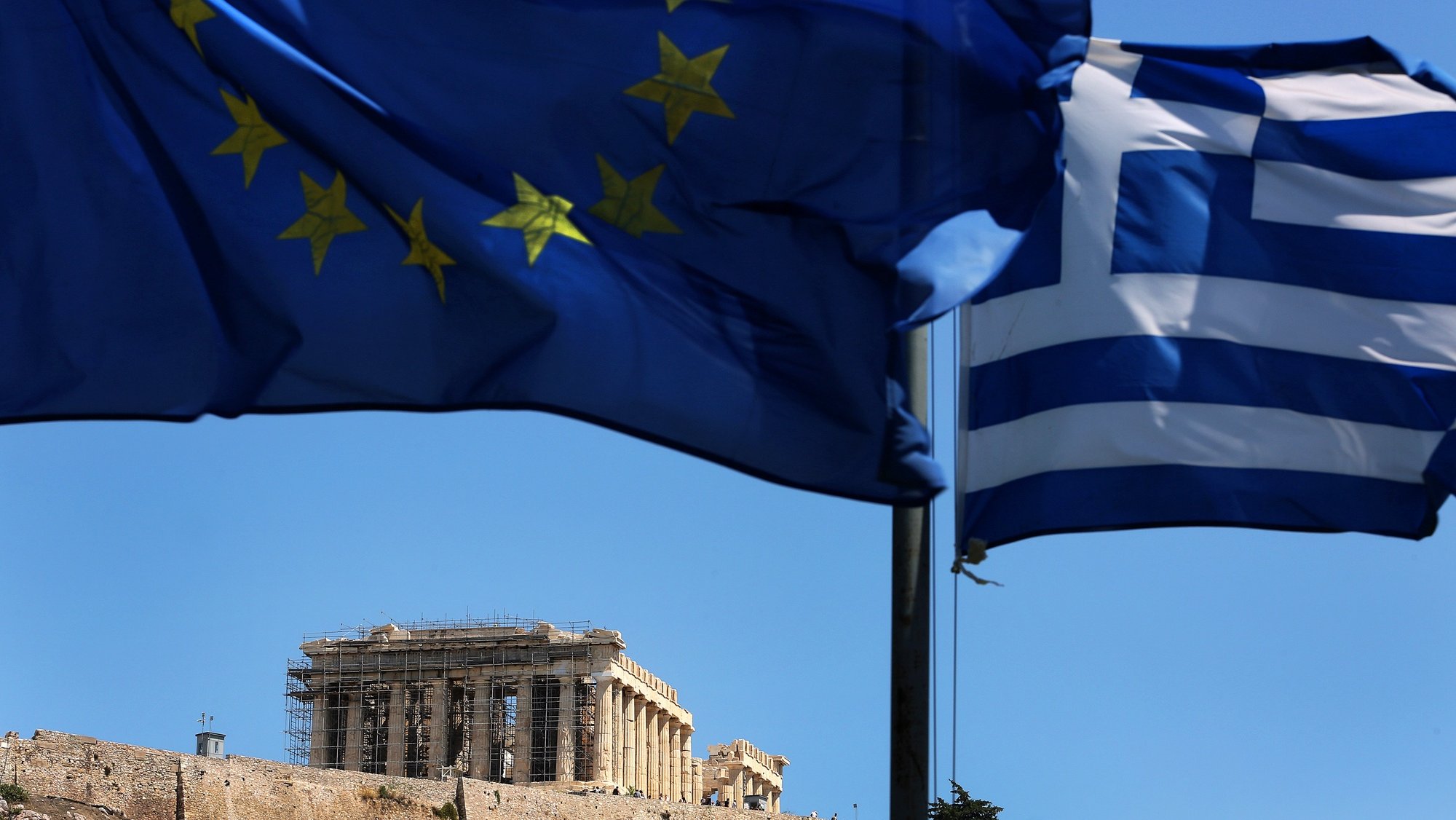 epa06960380 The Greek flag (R) and the flag of EU wave over the Parthenon on Acropolis Hill in central Athens, Greece, 20 August 2018. Greece concludes the adjustment program on August 20. Greece has successfully concluded a three year European Stability Mechanism (ESM) stability support programme, EU Commissioner Moscovici said.  EPA/SIMELA PANTZARTZI