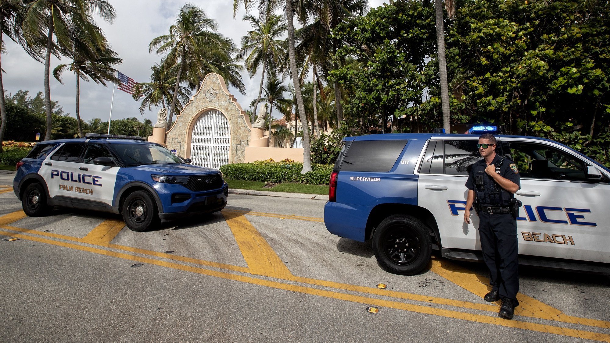 epa10112628 Authorities stand outside Mar-a-Lago, the residence of former president Donald Trump, amid reports of the FBI executing a search warrant as a part of a document investigation, in Palm Beach, Florida, USA, 09 August 2022.  EPA/CRISTOBAL HERRERA-ULASHKEVICH