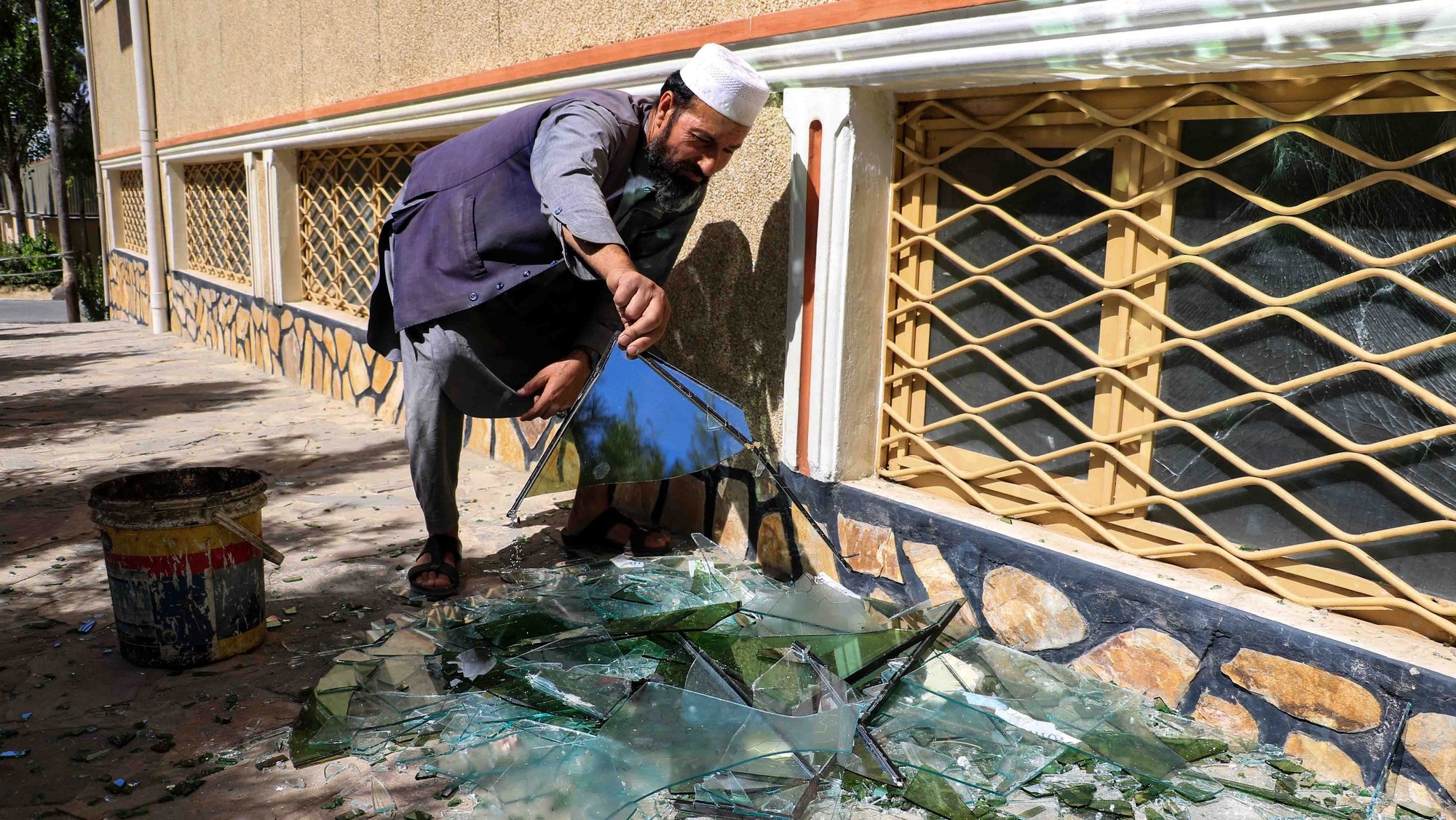 epa10020352 An Afghan man collects shattered window panes at the scene of an explosion in front of a Sikh temple, in Kabul, Afghanistan, 18 June 2022. Suicide attackers stormed a Sikh temple in the Afghan capital on 18 June morning, sparking a gun battle in which two people lost their lives, police said. &#039;The attack on the (Sikh) shrine ended with the elimination of the insurgents&#039;, Kabul police spokesperson Khalid Zadran said.  EPA/STRINGER