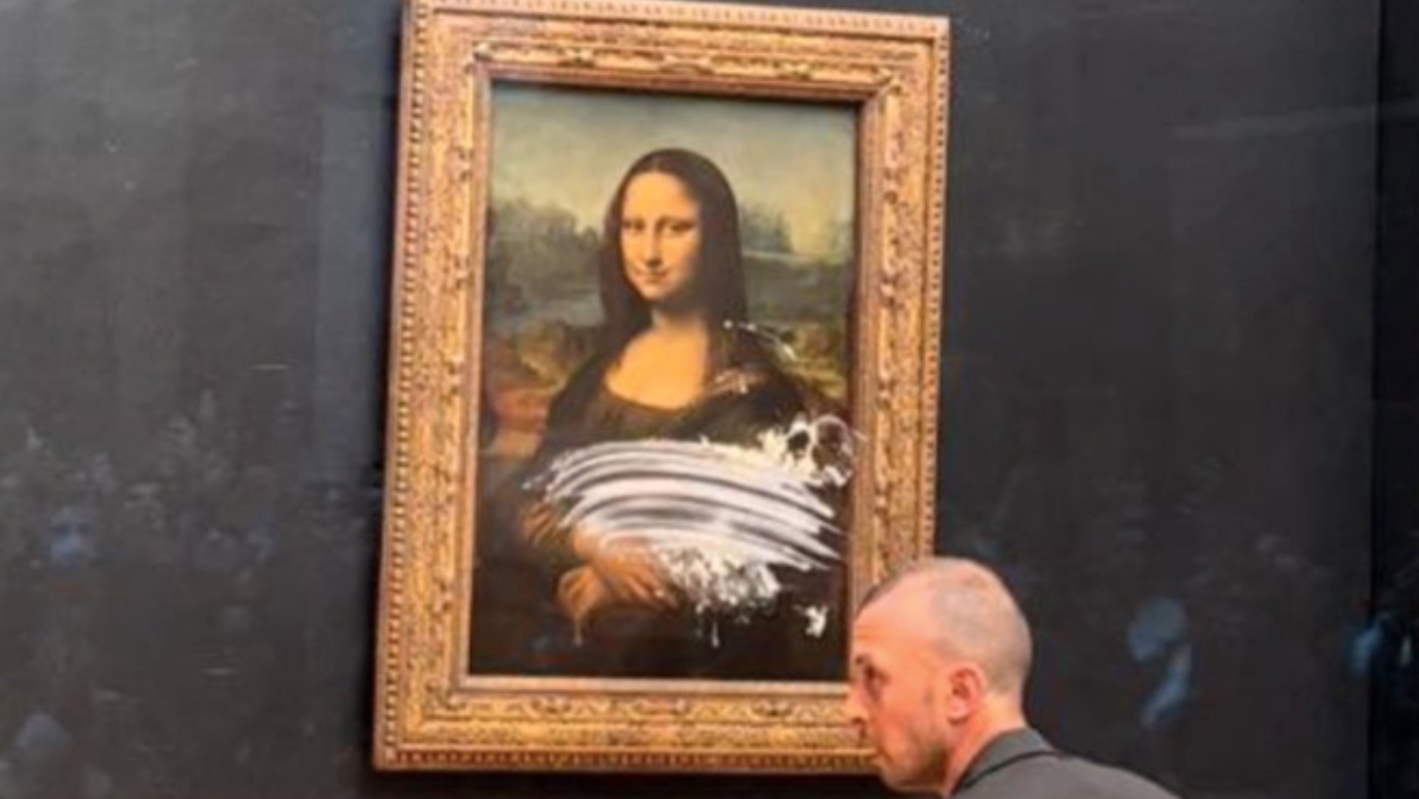 Man throws cake at Mona Lisa painting at Louvre Museum