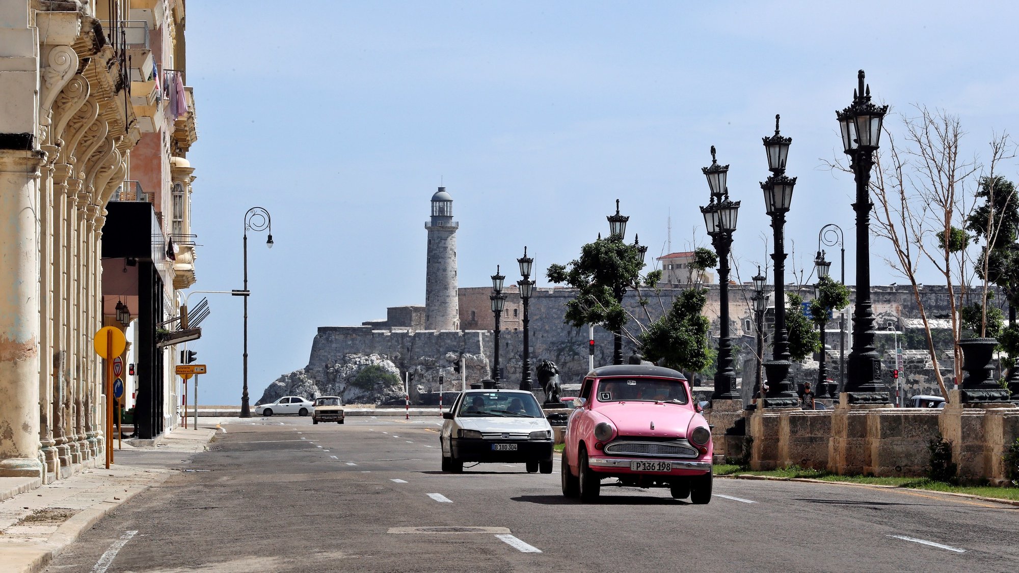 epa09340952 Several cars pass by the Paseo del Prado and next to the Castillo del Morro in Havana, Cuba, 12 July 2021. The streets of the Cuban capital remain calm one day after the large demonstrations against the government.  EPA/Ernesto Mastrascusa