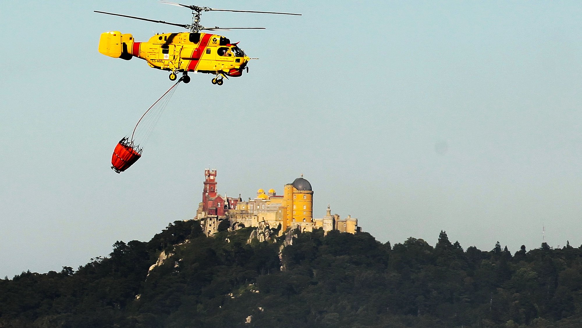 Um helicóptero combate o incêndio que deflagrou hoje numa área de mato ao início da tarde na Quinta da Capela, Sintra, 11 julho 2012. O fogo mobilizou 197 operacionais (194 bombeiros e três elementos de outras forças de socorro), 60 veículos e cinco meios aéreos. ANTONIO COTRIM/LUSA