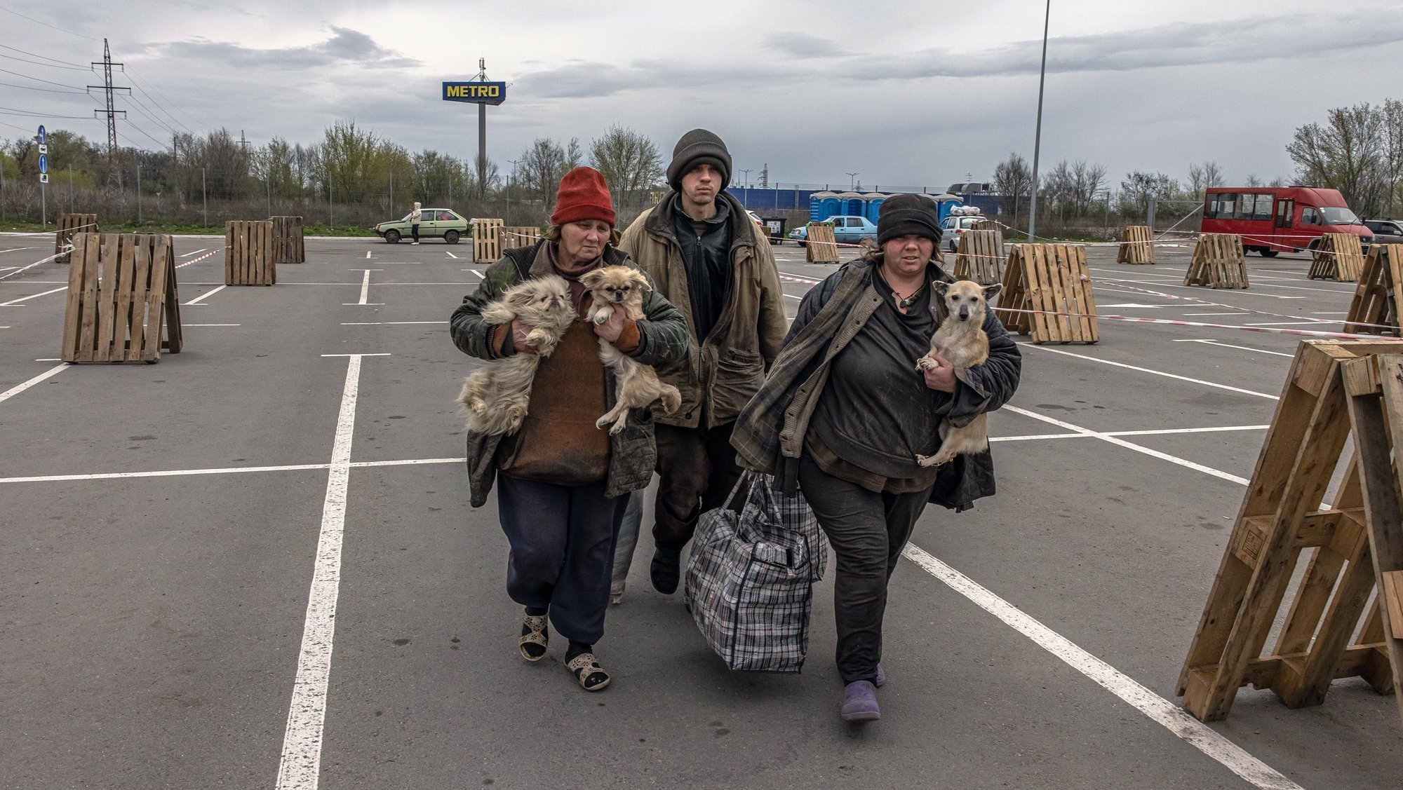 epaselect epa09905145 A mother (L) from the currently Russian-occupied urban-type settlement Myrne, which is near Melitopol, walks with her two adult children and dogs after arriving at the evacuation point in Zaporizhzhia, Ukraine, 23 April 2022. A woman said that her husband was killed by the shelling. Some parts of the route she and her two adult children were doing by foot. Thousands of people who still remained trapped in Mariupol and others occupied by the Russian army areas in South Ukraine wait to be evacuated to Ukraine&#039;s controlled area by buses and their own cars.  EPA-EFE/ROMAN PILIPEY