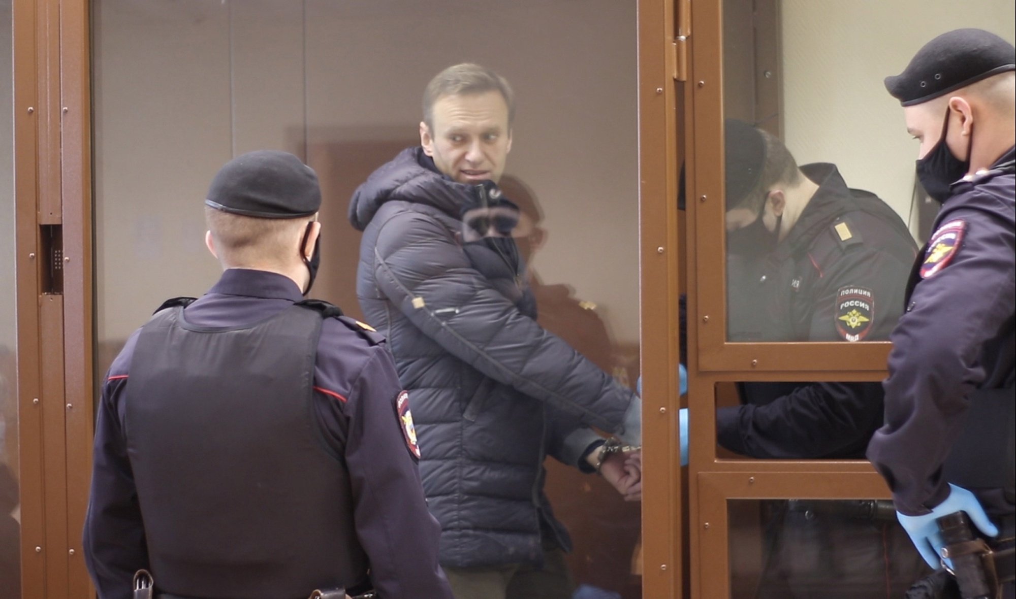 epa09015497 A still image taken from a handout video footage made available by the press service of the Babushkinsky district court shows Russian opposition leader Alexei Navalny (2-L) inside a glass cage prior to a hearing of a case on slander charges in Moscow, Russia, 16 February 2021. In June 2020 the Russian Investigative Committee opened a criminal case against Alexei Navalny on charges of slander against WWII veteran Ignat Artemenko after Navalny&#039;s comment about a video promoting the amendments to the Russian Constitution.  EPA/BABUSHKINSKY DISTRICT COURT PRES -- MANDATORY CREDIT -- BEST QUALITY AVAILABLE -- HANDOUT EDITORIAL USE ONLY/NO SALES