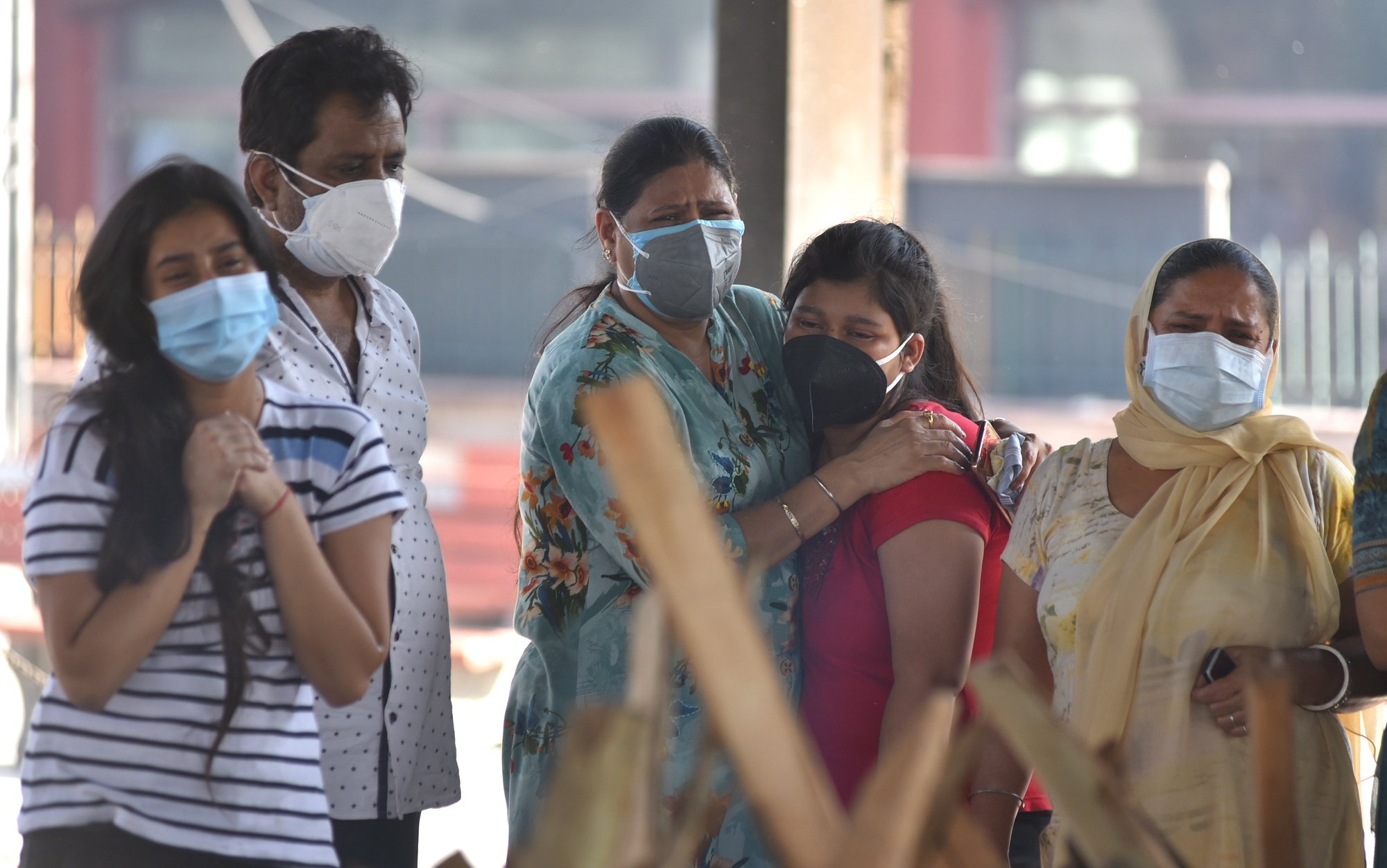 epa09226058 Family members of a COVID-19 victim react as they attend the victim&#039;s cremation in New Delhi, India, 24 May 2021 (issued 25 May 2021). India reports 1,96,427 new COVID-19 cases in the last 24 hours with 3,511 deaths.  EPA/IDREES MOHAMMED
