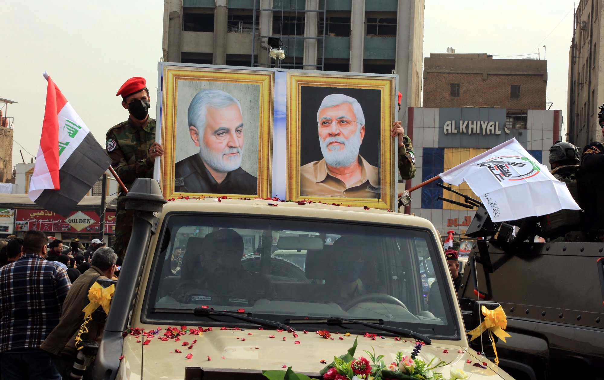 epa09659467 Members of Iraqi Shiite armed groups popular mobilization forces carry the pictures of slain Abu Mahdi al-Muhandis and general Qasem Soleimani, the head of Iran&#039;s Islamic Revolutionary Guard Corps&#039; elite Quds Force, during a symbolic funeral of Shiite fighters who were killed in a US airstrike near the Iraqi border with Syria, in central Baghdad, Iraq, 29 December 2021. Hundreds of Iraqi Shiite armed groups popular mobilization forces members staged a symbolic funeral on the second anniversary of the killing of 36 fighters of Shiite fighters in US airstrikes against their locations on the Iraq-Syria border on late December 2019, in response to drone attacks on its forces in Iraq.  EPA/AHMED JALIL