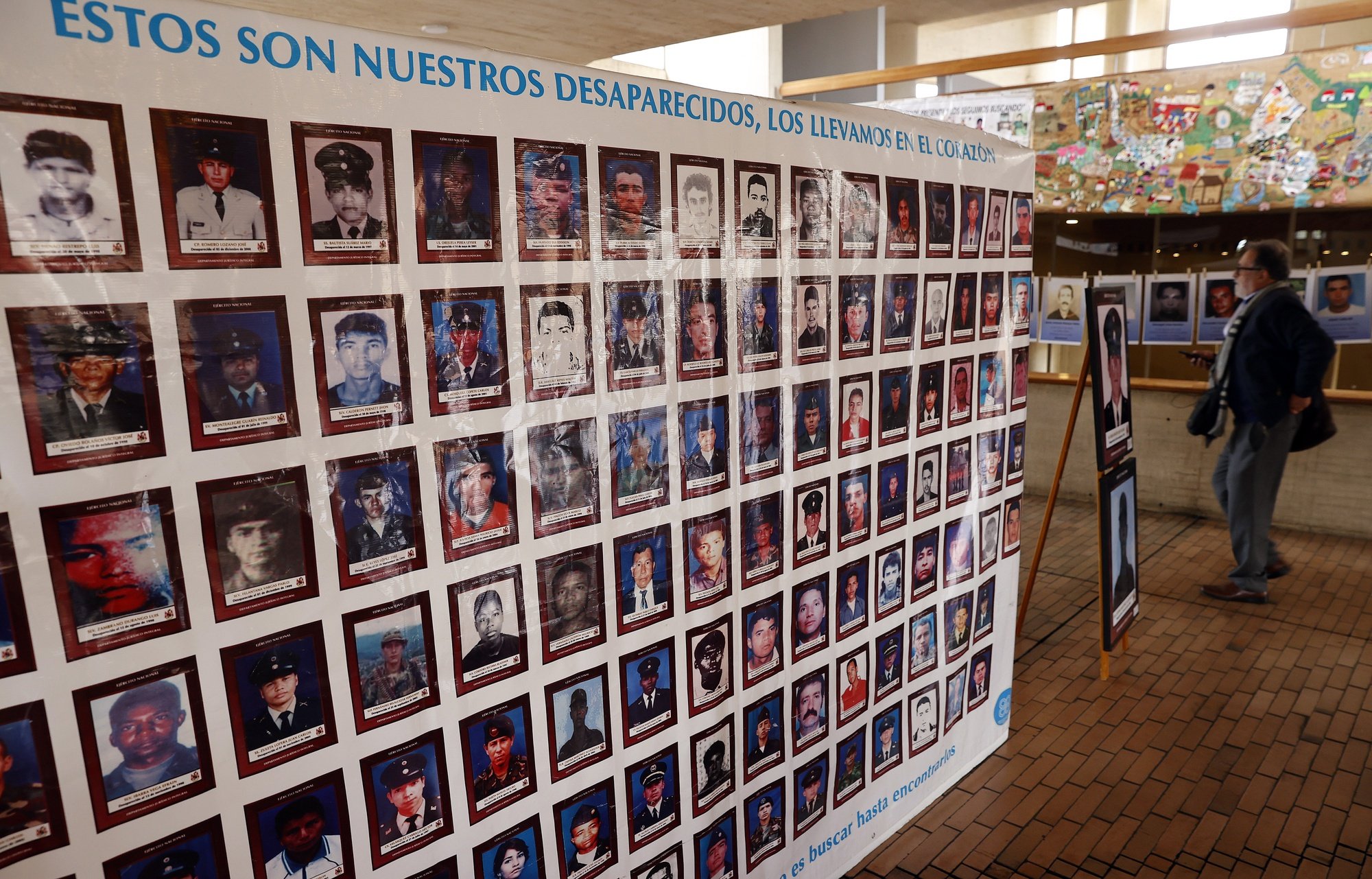 epa10028810 Visitors to the Virgilio Barco library observe an exhibition with the faces of kidnap victims during the process known as &#039;Case 01&#039; of the Special Justice for Peace (JEP), in Bogota, Colombia 22 June 2022. The horrors of the kidnappings committed by the FARC came to light when a group of victims recounted before the JEP, the physical, economic, and emotional suffering, they encountered.  EPA/Mauricio Duenas Castaneda