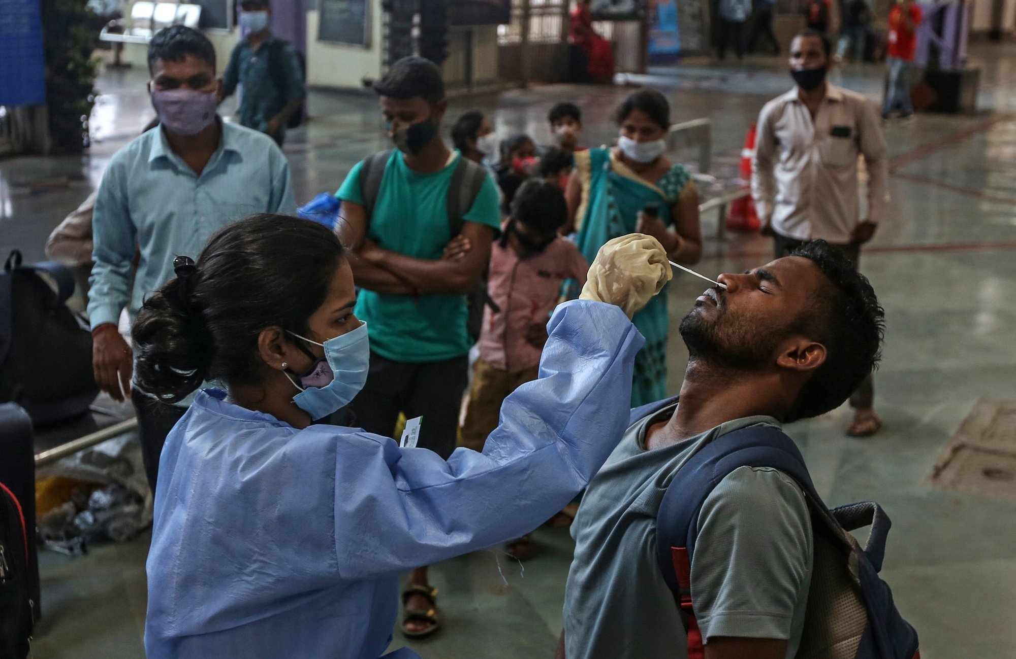 epa09139251 A health worker takes a nasal swab sample of a person to test for COVID-19 at Chhatrapati Shivaji Maharaj Terminus railway station in Mumbai, India, 16 April 2021. A curfew is announced in Mumbai, and many other states as India recorded its highest daily spike of COVID-19 cases on 14 April with around 200,000 new infections in 24 hours.  EPA/DIVYAKANT SOLANKI