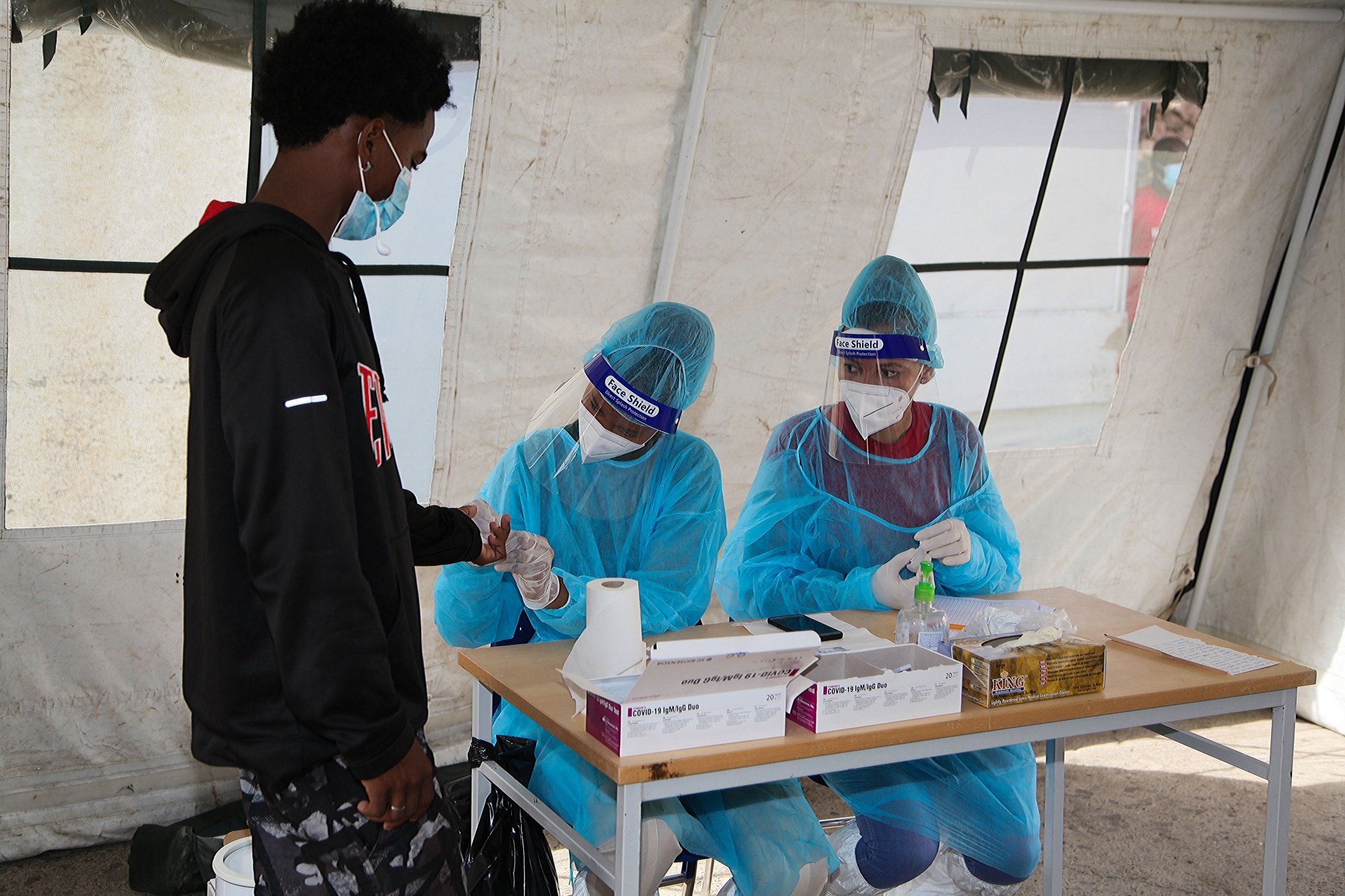 Técnicos de saúde recolhem amostras de sangue numa tenda de testes rápidos no âmbito das atividades de controlo da covid-19 na Cidade da Praia, Cabo Verde, 26 de maio de 2020. FERNANDO DE PINA/LUSA