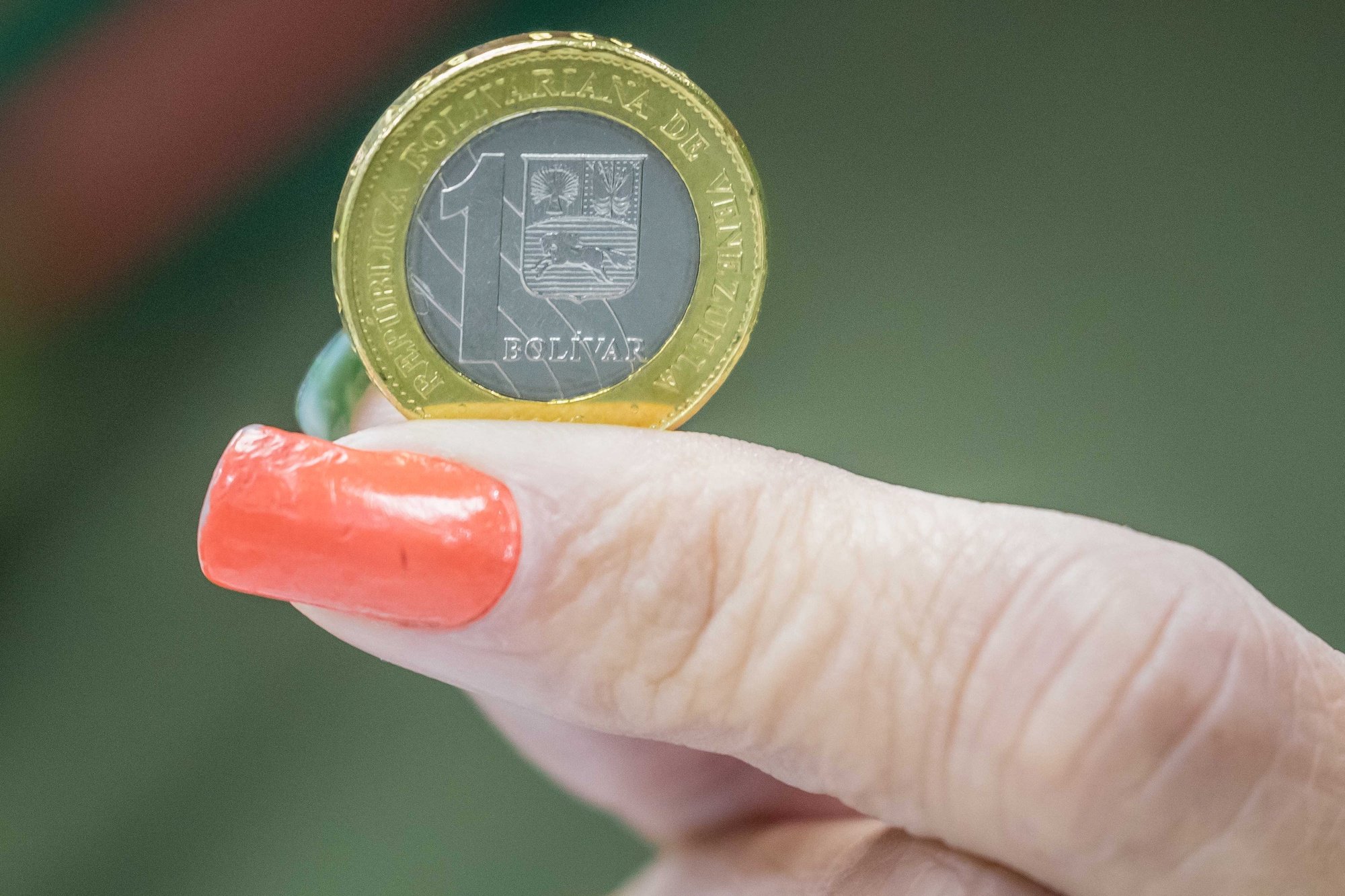 epa06960657 View of a coin part of the new currency in Caracas, Venezuela, 20 August 2018. Starting today, the Bolivar Soberano is the official currency in Venezuela, with a new design of the bills and slashing five zeroes in relation to the Bolivar Fuerte. The crypto-currency Petro will be the secondary and also valid currency.  EPA/Miguel GutiÃ©rrez