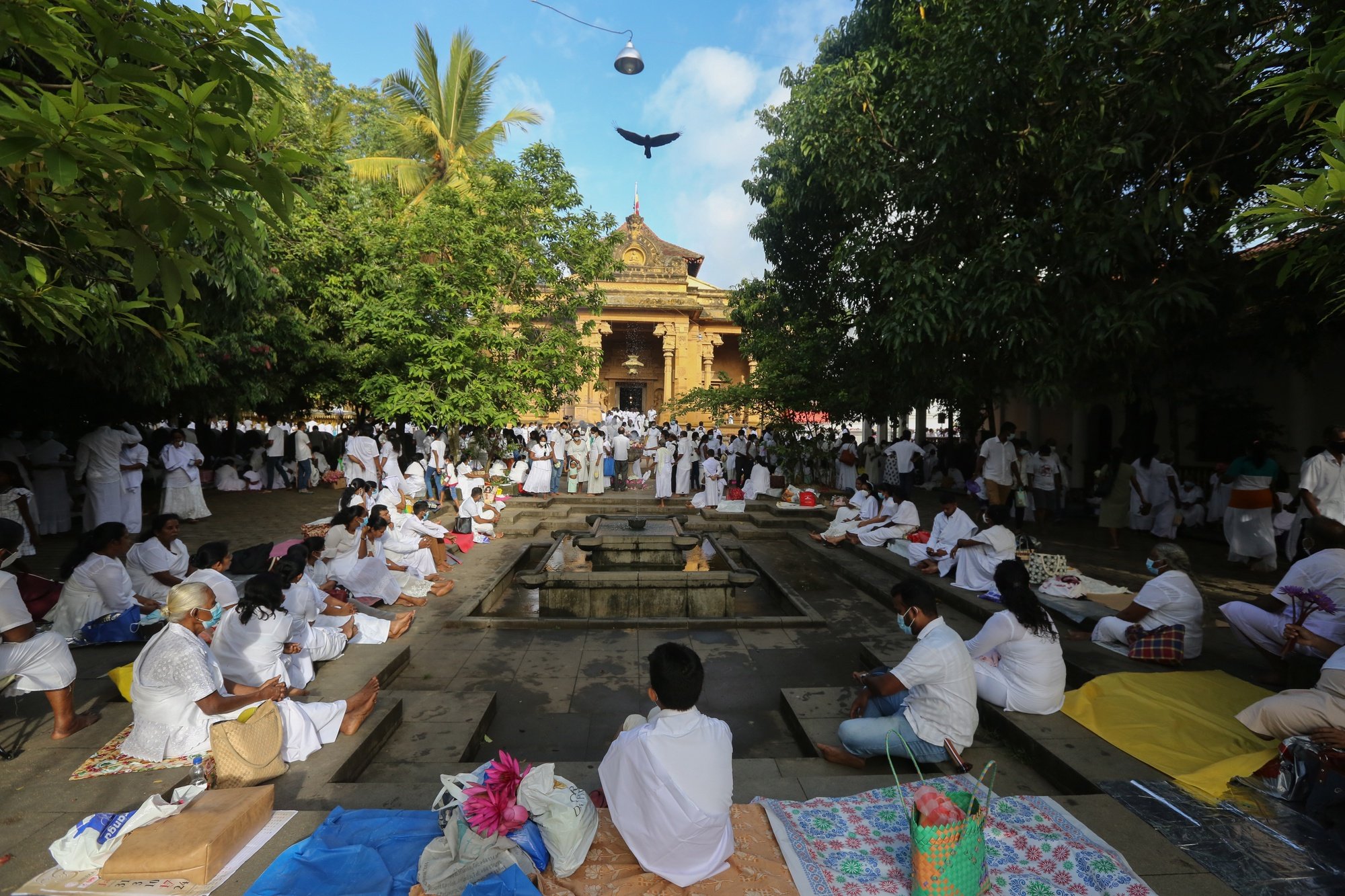 epa09948117 Sri Lankan Buddhist devotees take part in a religious observance on the Vesak full moon day at a temple in the Kelaniya suburb of Colombo, Sri Lanka, 15 May 2022. Vesak is the full moon day of the month of May and is the most sacred day for Buddhists in Sri Lanka and around the world. Buddhists commemorate the birth, enlightenment, and death of the Buddha on the full moon day.  EPA/CHAMILA KARUNARATHNE