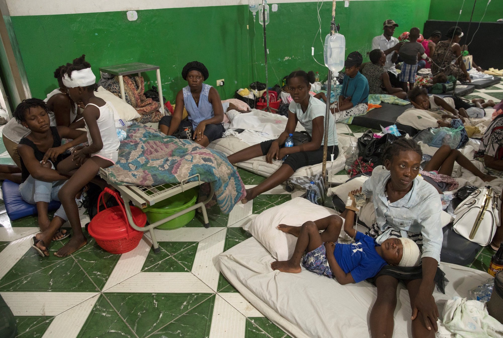 epa09417280 Patients and their families gather at Les Cayes General Hospital, in Les Cayes, Haiti, 16 August 2021. Hospitals in southwestern Haiti are at the limit, while the authorities increased the number of deaths to 1,419 and the number of injured to 6,900 due to the strong 7.2 magnitude earthquake which occured on 14 August.  EPA/Orlando Barria