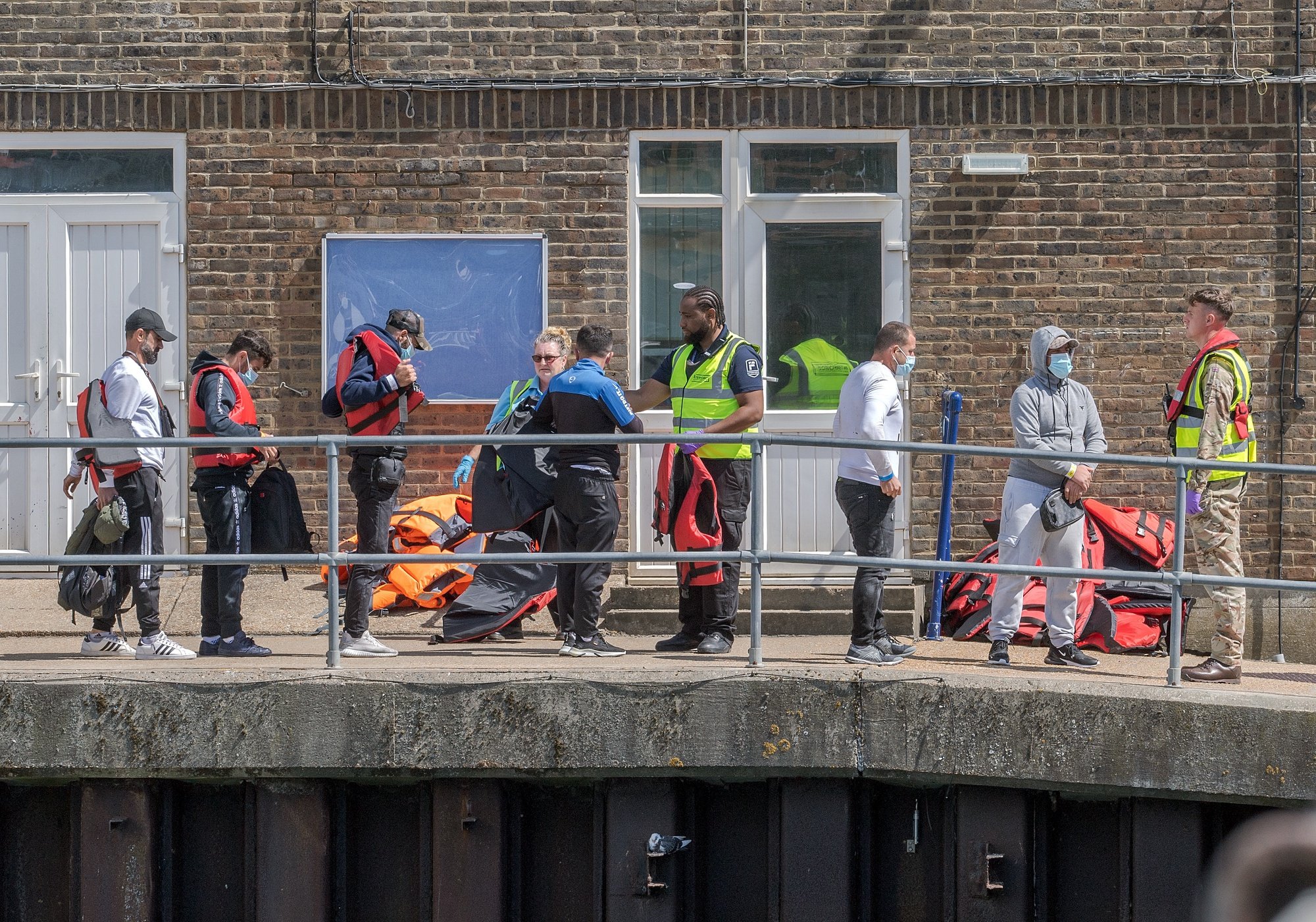 epa10105790 Migrants after disembarking a Border Force vessel which escorted 70 migrants after they were picked up in the English Channel, Dover, Britain, 04 August 2022. A report from the United Nations High Commissioner for Refugees and the British Red Cross has found that critical gaps in the UK asylum system may result in people being at risk of potential exploitation when they arrive in the UK.  EPA/Stuart Brock
