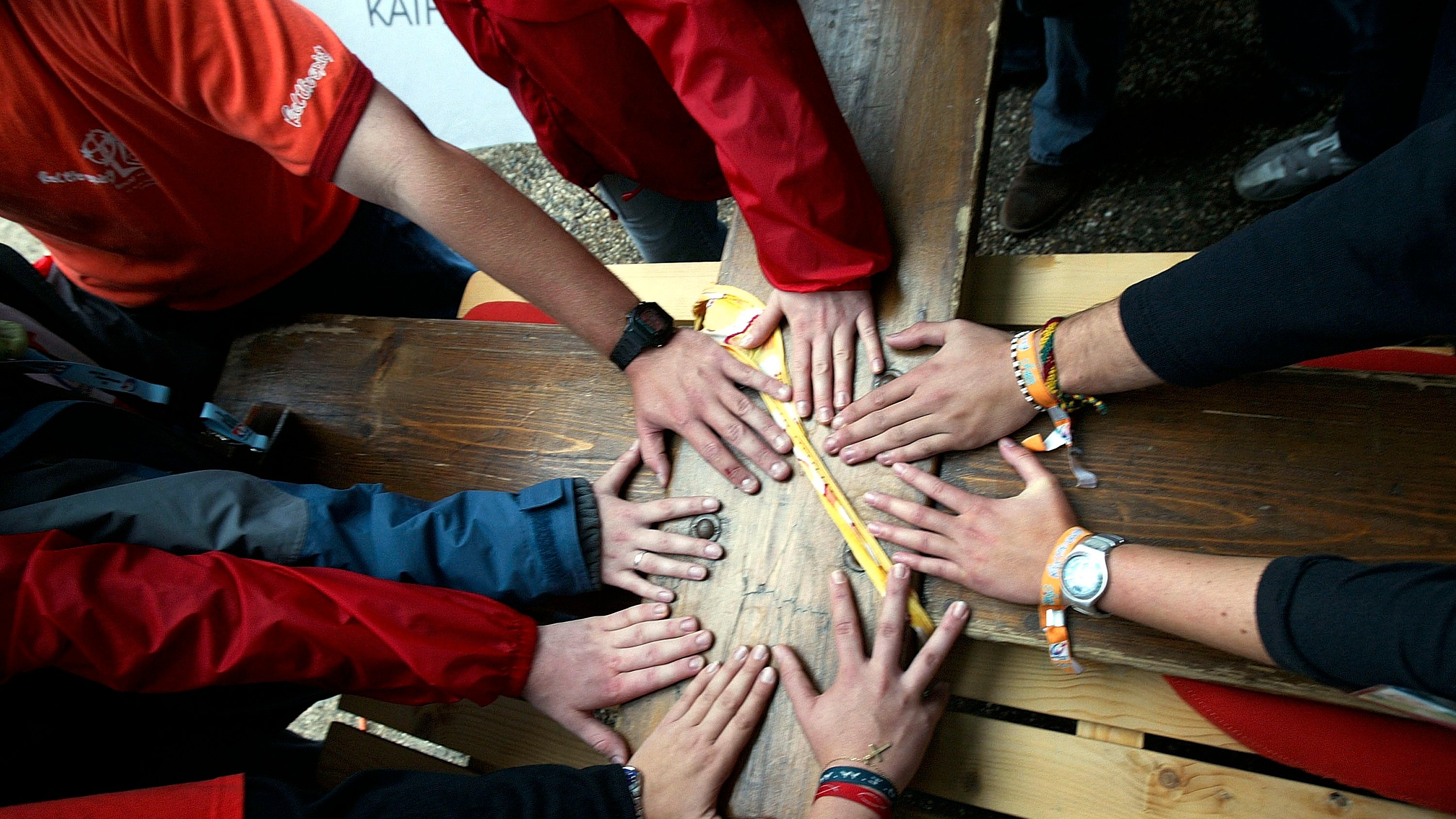 Na imagem: as mãos de várias pessoas juntas em união
