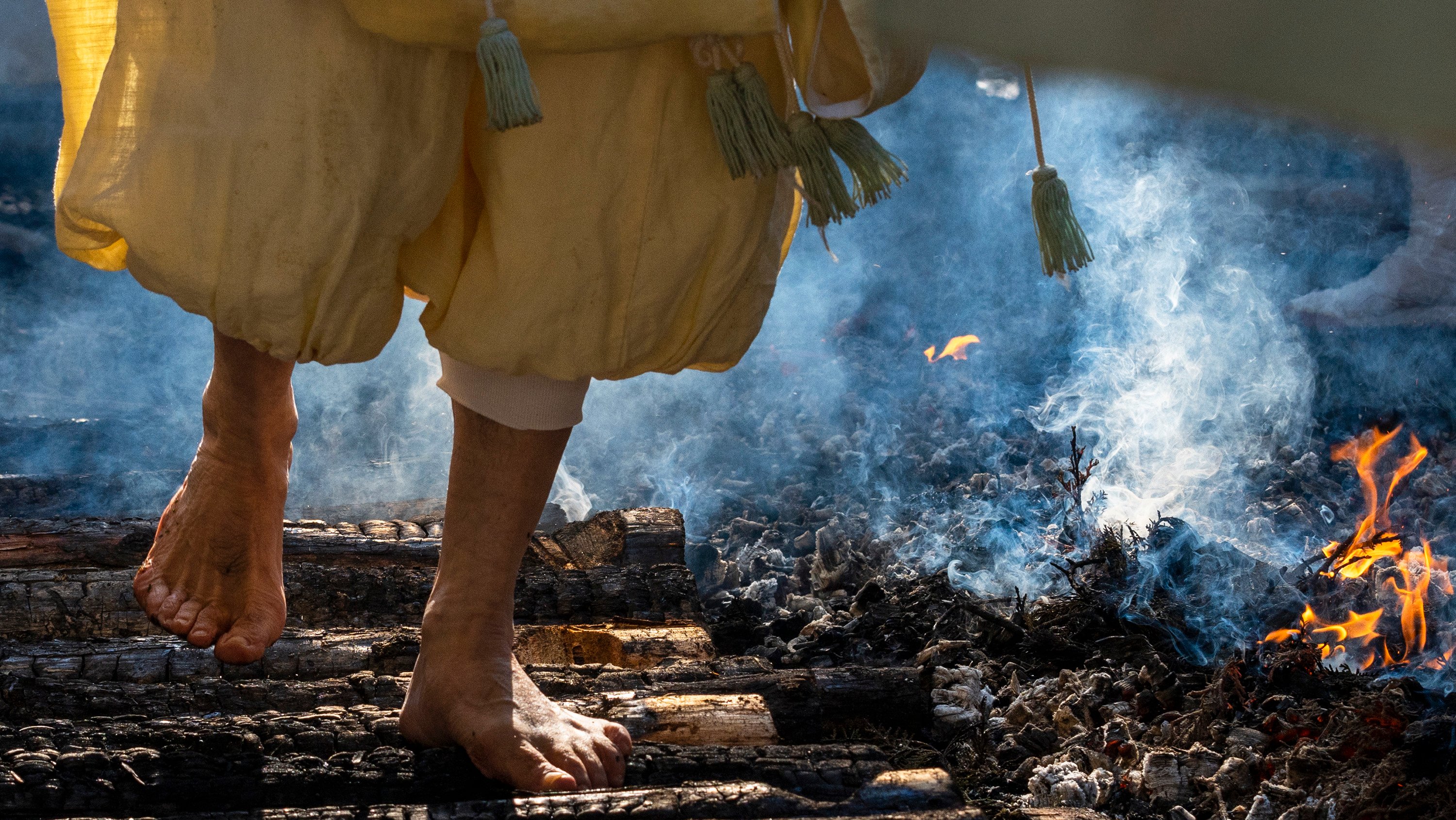 Um sacerdote Yamabushi caminha descalço sobre troncos queimados como ritual de Ano Novo, no Japão