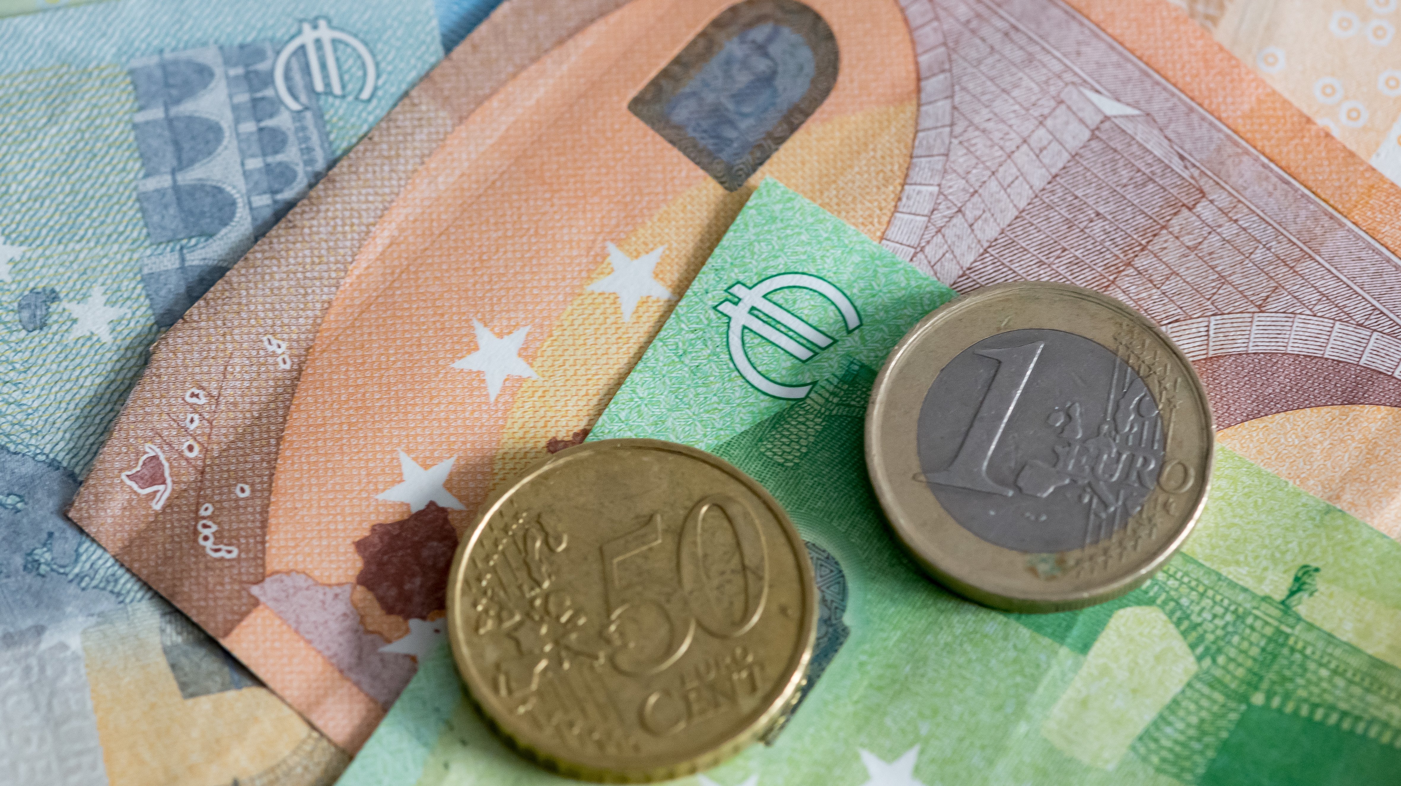 photo illustration: Euro banknotes with coins