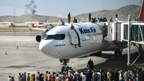 Afegãos agarram-se a aviões da Kam Air, a companhia aérea do Afeganistão, que estão a descolar do aeroporto de Cabul numa tentativa de fuga