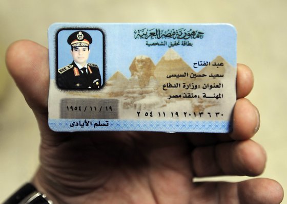 An Egyptian man displays a fake ID of Egypt's army chief Field Marshal Abdel Fattah al-Sisi which is being sold in the streets of Cairo as part of paraphernalia in support of Sisi's candidacy for the upcoming presidential elections, on January 28, 2014 in Cairo. Three years after a popular uprising forced out ex-general Hosni Mubarak, Egypt's army is again pushing a commander to stand for president after he ousted the first civilian head of state. The army endorsed its Field Marshall Abdel Fattah al-Sisi's candidacy for a presidential election scheduled to be held by mid-April. On of the writings in Arabic read: "Occupation: savior of Egypt".  AFP PHOTO/FAYEZ NURELDINE        (Photo credit should read FAYEZ NURELDINE/AFP/Getty Images)