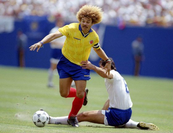 5 JUN 1994:  CARLOS VALDERRAMA CAPTAIN OF COLOMBIA RIDES A TACKLE BY PETER TSALOHIDIS DURING COLOMBIA''S 2-0 WIN OVER GREECE IN A WORLD CUP WARM UP GAME AT GIANTS STADIUM IN  THE MEADOWLANDS NEW JERSEY. Mandatory Credit: Simon Bruty/ALLSPORT