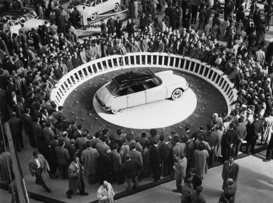 Crowds at the Paris Motor Show in the Grand Palais surround a Citroen DS-19 on display. (Photo by Keystone/Getty Images)