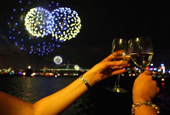 SYDNEY, AUSTRALIA - DECEMBER 31:  People toast their wine glasses as the annual New Year's Eve fireworks display illuminates the sky over Sydney Harbour on December 31, 2009 in Sydney, Australia. The 2009 into 2010 theme is 'Awaken The Spirit' with over 1.5 million people expected to gather around the harbour to watch the 12 minute show.  (Photo by Ryan Pierse/Getty Images)