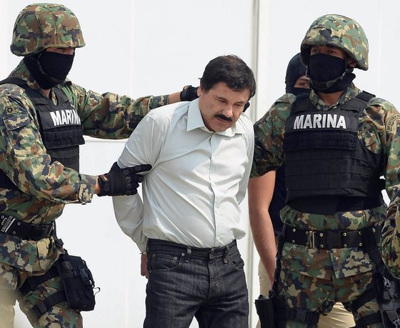 Mexican drug trafficker Joaquin Guzman Loera aka "el Chapo Guzman" (C), is escorted by marines as he is presented to the press on February 22, 2014 in Mexico City. The Sinaloa cartel leader - the most wanted by US and Mexican anti-drug agencies - was arrested early this morning by Mexican marines at a resort in Mazatlan, northern Mexico. AFP PHOTO/Alfredo Estrella        (Photo credit should read ALFREDO ESTRELLA/AFP/Getty Images)