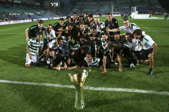 epa04878803 Sporting Clube de Portugal players celebrate with the 'Candido de Oliveira' Supercup trophy after a win over Sport Lisboa e Benfica in a match held at Algarve Stadium in Faro, Portugal, 09 August 2015.  EPA/JOSÃ‰ SENA GOULÃƒO