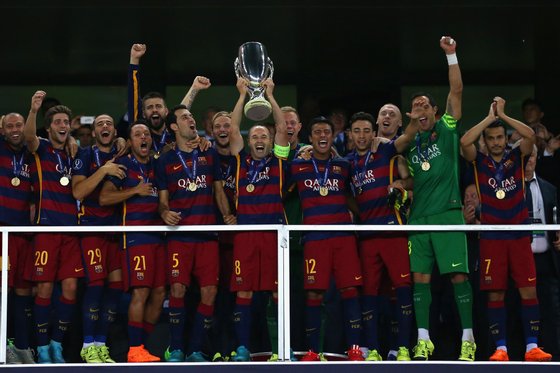 TBILISI, GEORGIA - AUGUST 11:  Andres Iniesta of Barcelona lifts the UEFA Cup trophy as Barcelona celebrate victoy during the UEFA Super Cup between Barcelona and Sevilla FC at Dinamo Arena on August 11, 2015 in Tbilisi, Georgia.  (Photo by Chris Brunskill/Getty Images)