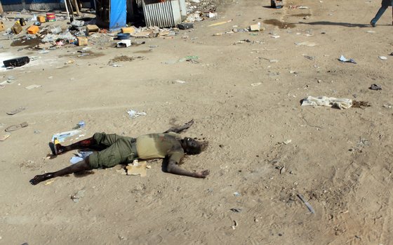 The body of a man claimed to be a rebel lies on the ground in the market in the centre of Bor, some 200 kilometres (125 miles) north of the capital Juba, on December 25, 2013. South Sudan's army stormed the rebel-held town of Bor on December 24, sending insurgents fleeing nearly a week after they captured the state capital of South Sudan's power-key eastern state of Jonglei. AFP PHOTO / WAAKHE SIMON WUDU (Photo credit should read WAAKHE SIMON WUDU/AFP/Getty Images)